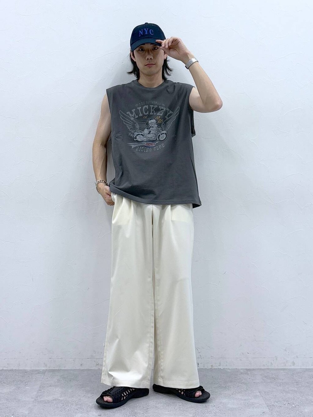 ホワイト系のスラックス、ブラック系のタンクトップを着用したメンズの春コーディネートの4枚目の写真