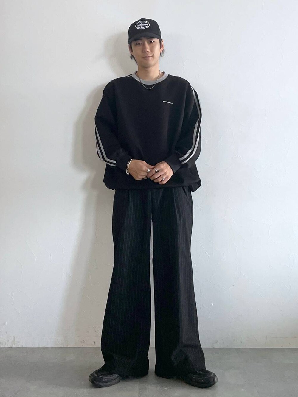 ブラック系のスラックス、ブラック系のスウェット、シルバー系のネックレスを着用したメンズの秋コーディネートの2枚目の写真