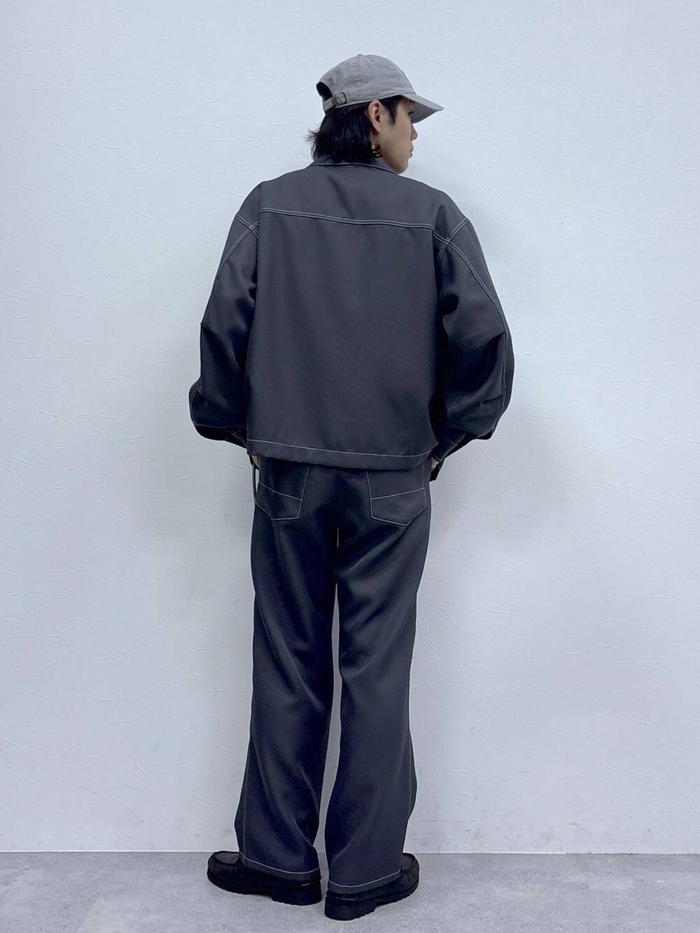 グレー系のブルゾン、グレー系のスラックス、ホワイト系のTシャツ/カットソーを着用したメンズの秋コーディネートの7枚目の写真