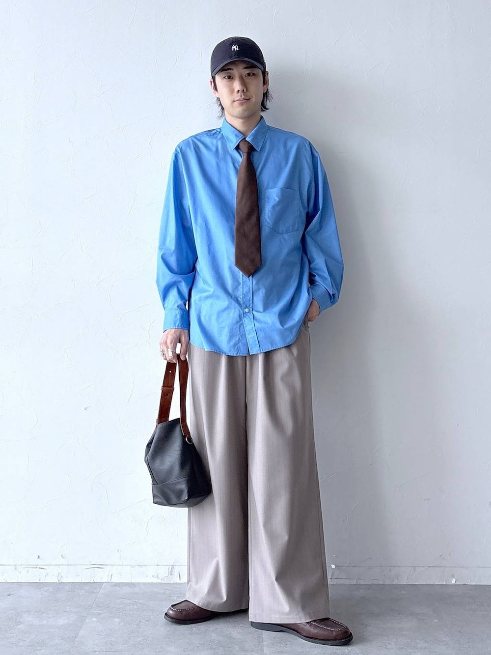 イエロー系のスラックス、ブラウン系のネクタイ、ブラウン系のモカシン/デッキシューズを着用したメンズの春コーディネートの3枚目の写真