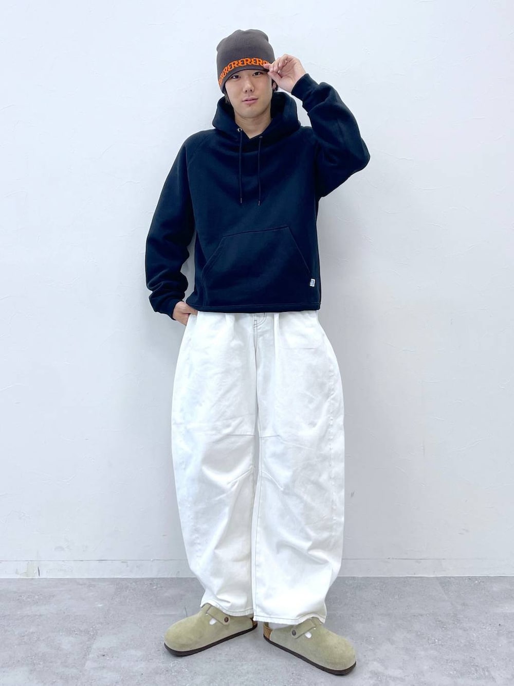 ブラック系のパーカー、ホワイト系のデニムパンツ、ブラウン系のニットキャップ/ビーニーを着用したメンズの秋コーディネートの3枚目の写真