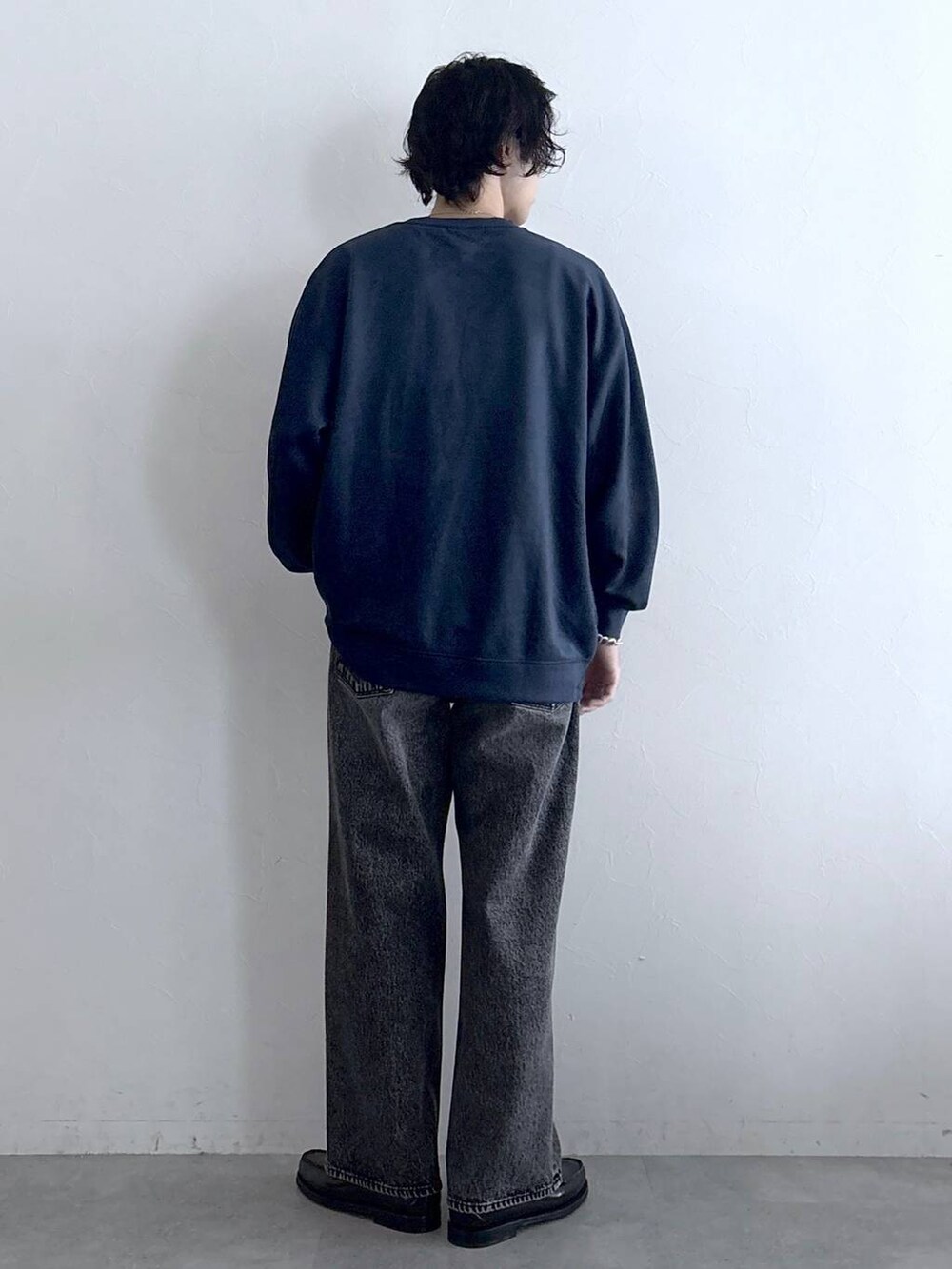 ブルー系のスウェット、グレー系のデニムパンツ、その他のネックレスを着用したメンズの冬コーディネートの7枚目の写真