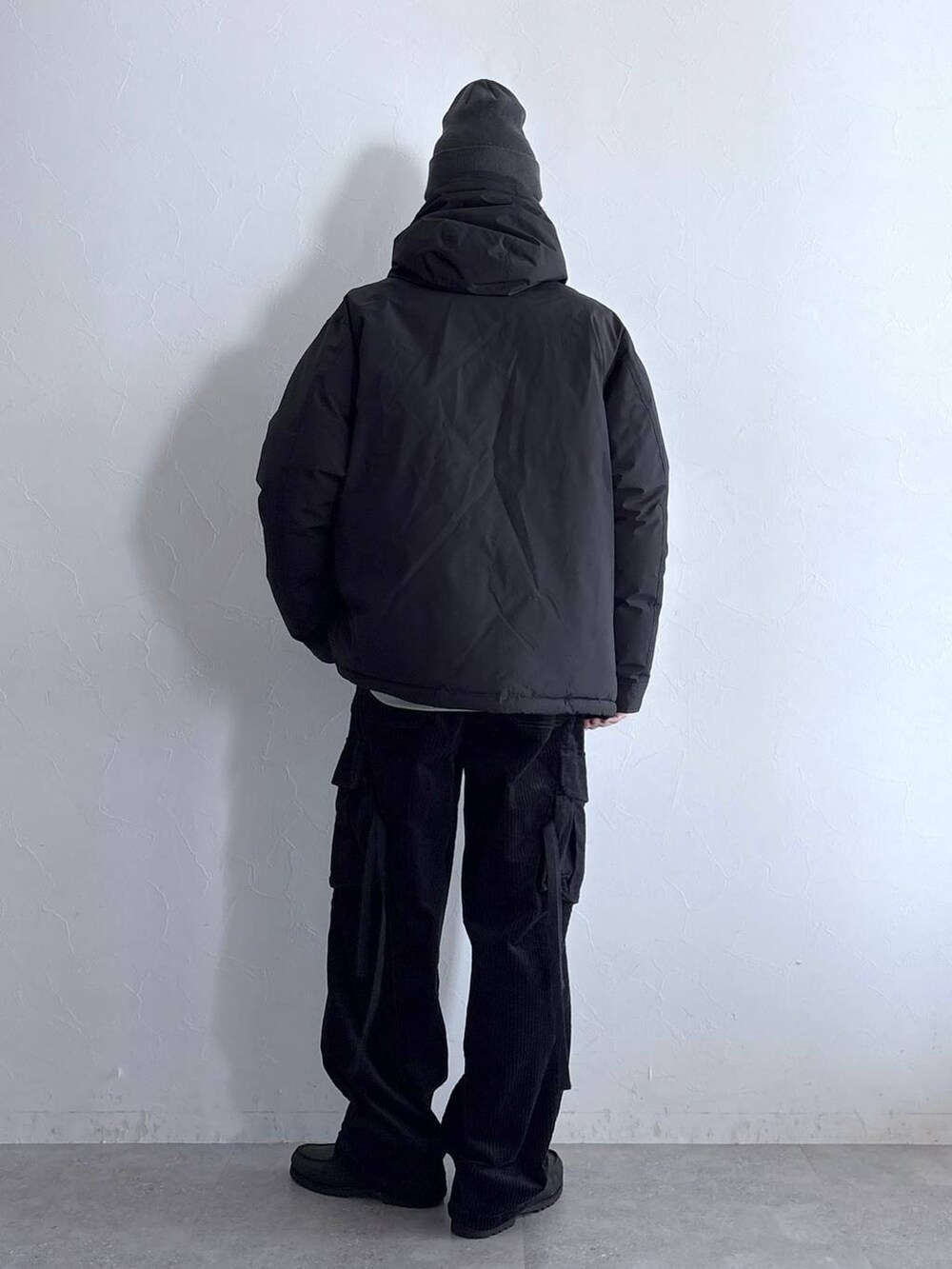 ブラック系のダウンジャケット/コート、ブラック系のカーゴパンツ、その他のネックレスを着用したメンズの冬コーディネートの7枚目の写真