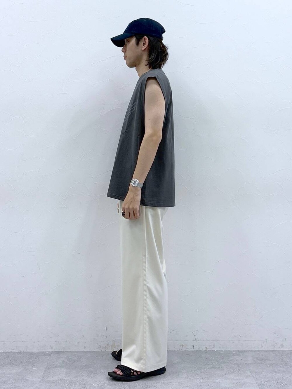 ホワイト系のスラックス、ブラック系のタンクトップを着用したメンズの春コーディネートの6枚目の写真