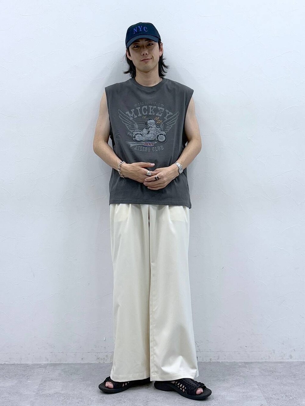 ホワイト系のスラックス、ブラック系のタンクトップを着用したメンズの春コーディネートの3枚目の写真