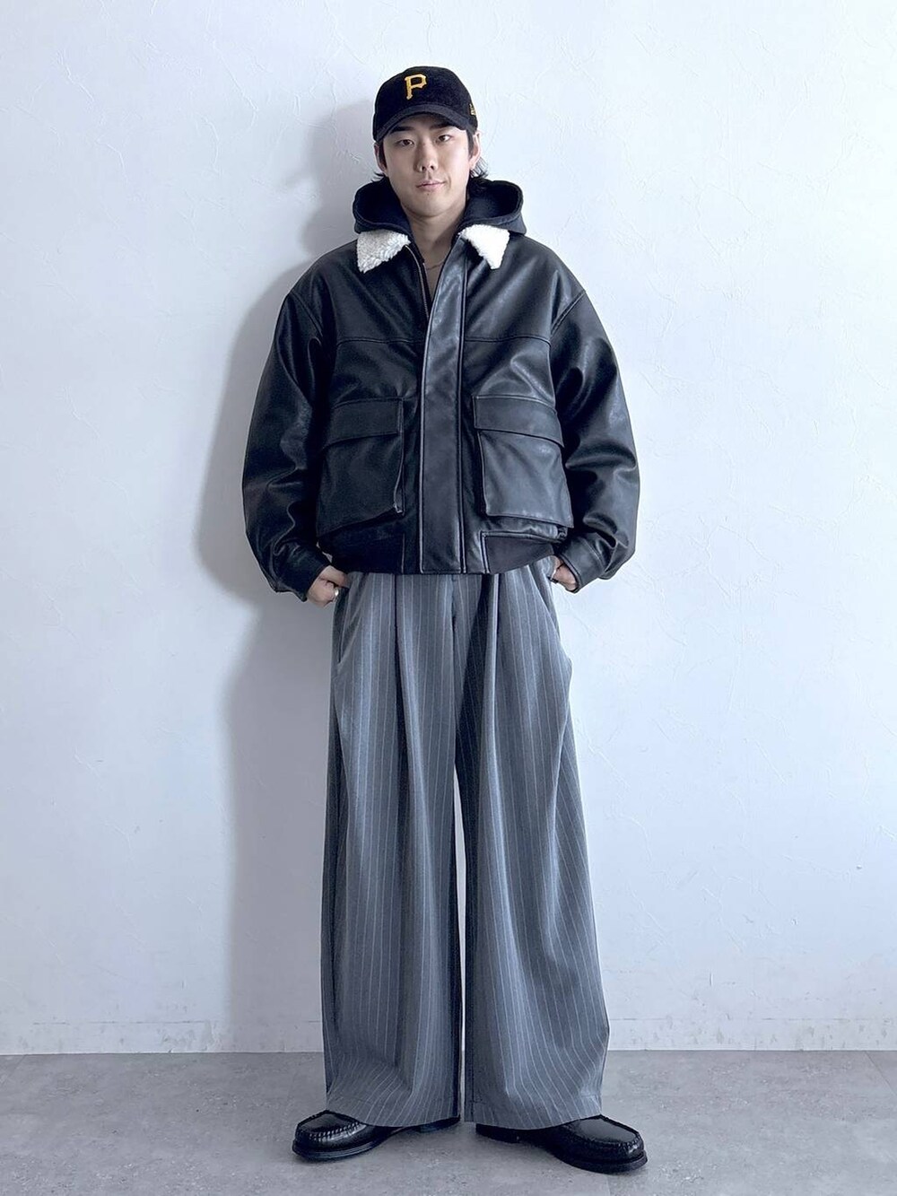 ブラック系のブルゾン、グレー系のスラックス、グレー系のパーカーを着用したメンズの冬コーディネートの3枚目の写真