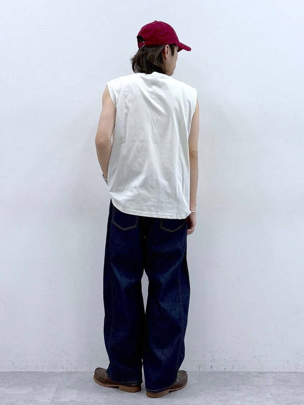 ホワイト系のタンクトップ、ブルー系のデニムパンツを着用したメンズの春コーディネートの7枚目の写真