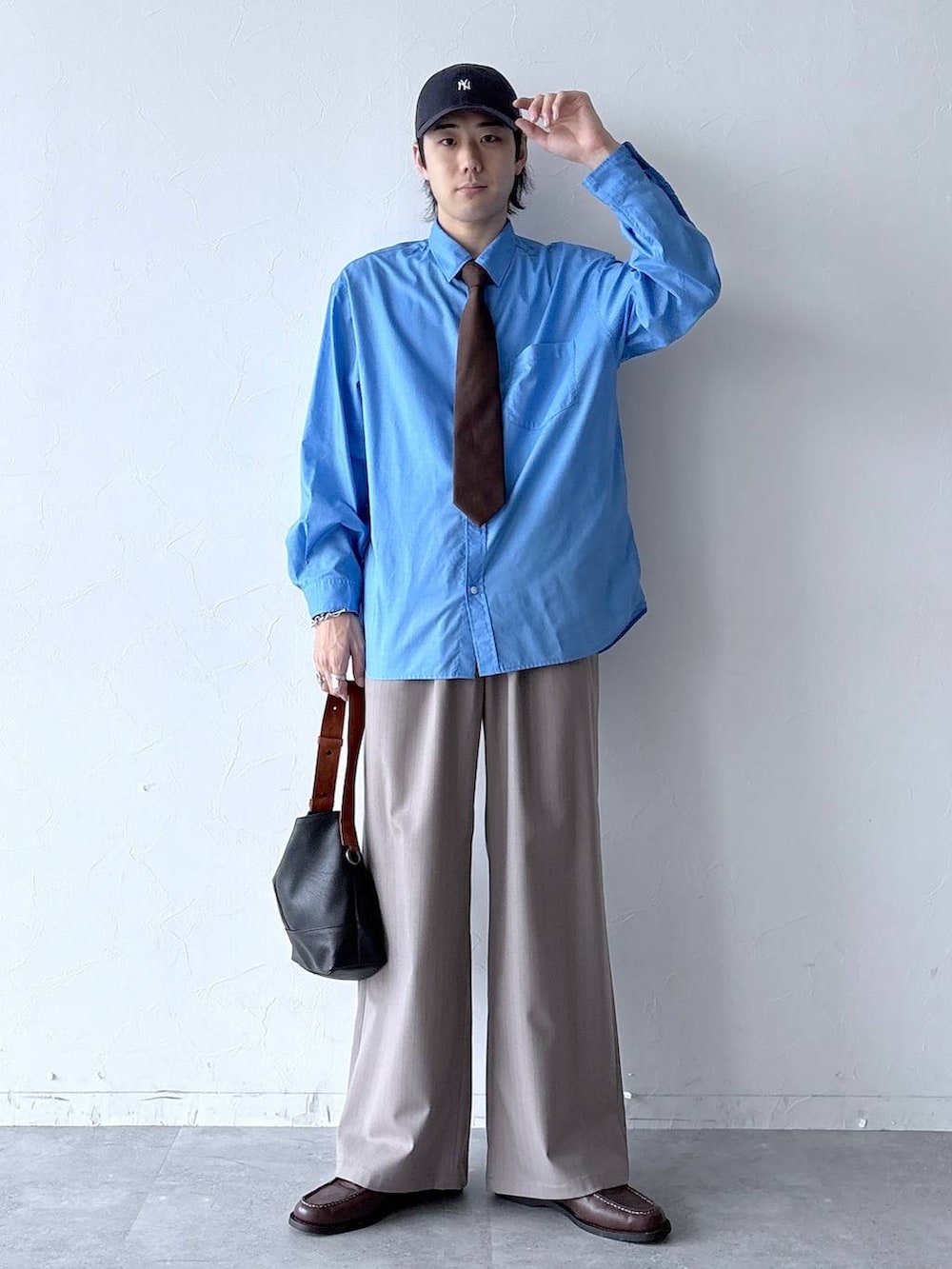 イエロー系のスラックス、ブラウン系のネクタイ、ブラウン系のモカシン/デッキシューズを着用したメンズの春コーディネートの2枚目の写真