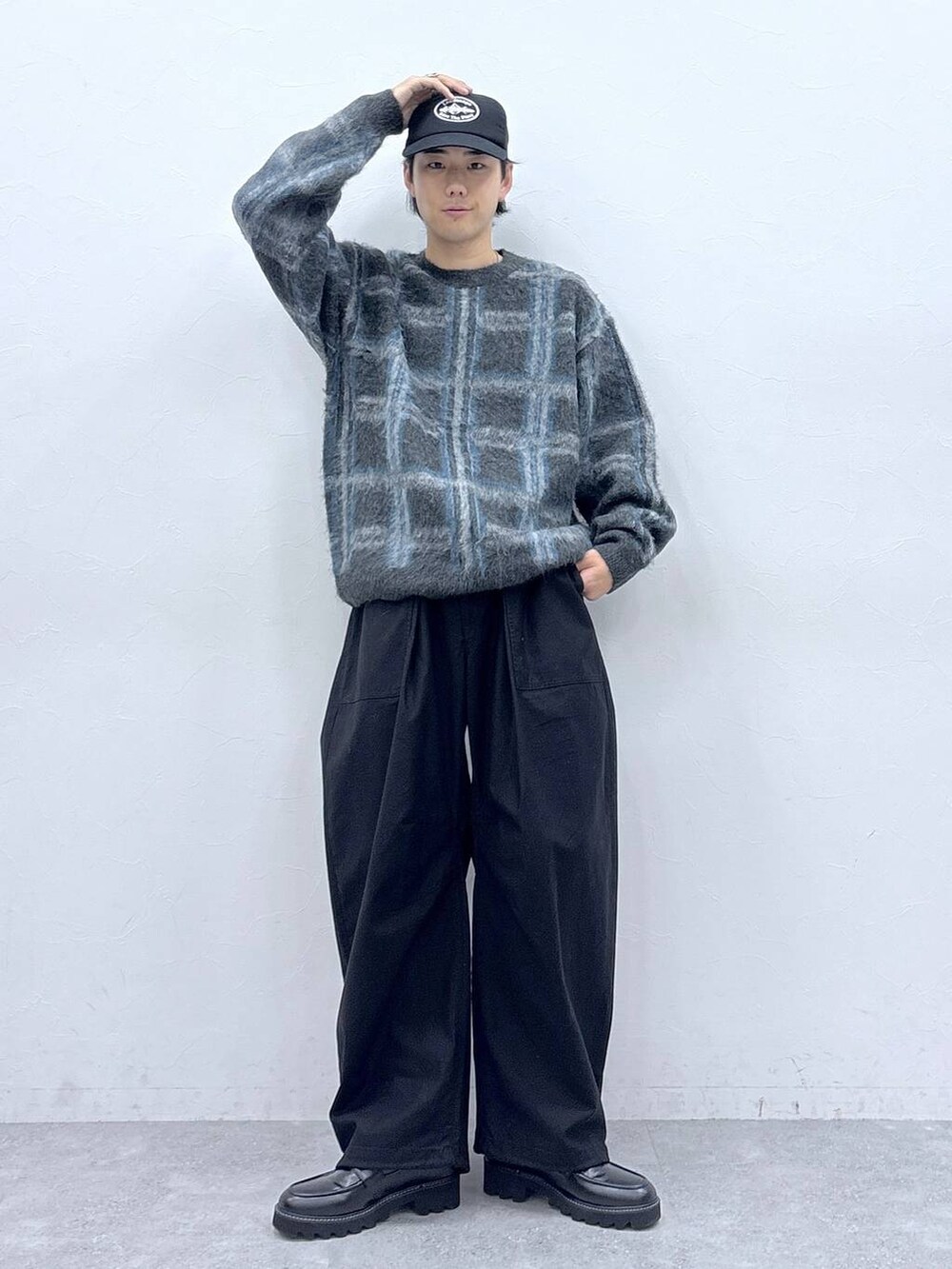 ブラック系のドレスシューズ、グレー系のニット/セーター、ブラック系のキャップを着用したメンズの秋コーディネートの6枚目の写真