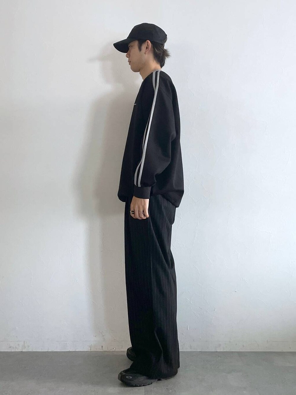 ブラック系のスラックス、ブラック系のスウェット、シルバー系のネックレスを着用したメンズの秋コーディネートの4枚目の写真