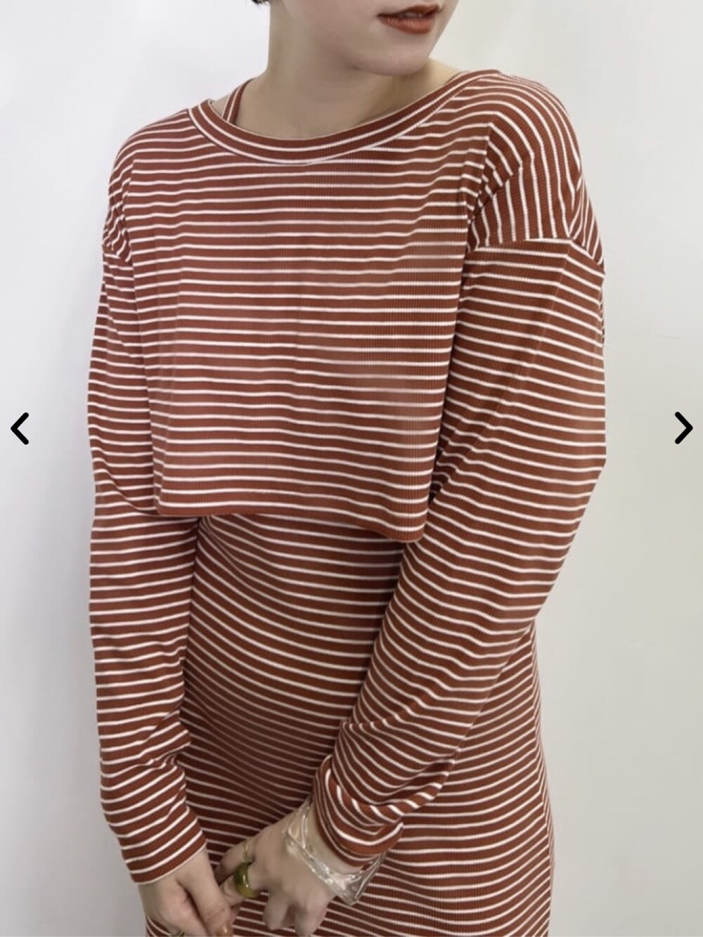 オレンジ系のワンピース、ブラック系のブーツを着用したレディースの夏コーディネートの3枚目の写真