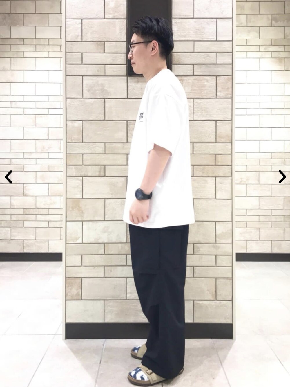 ホワイト系のTシャツ/カットソー、ブラック系のカーゴパンツを着用したメンズの夏コーディネートの2枚目の写真