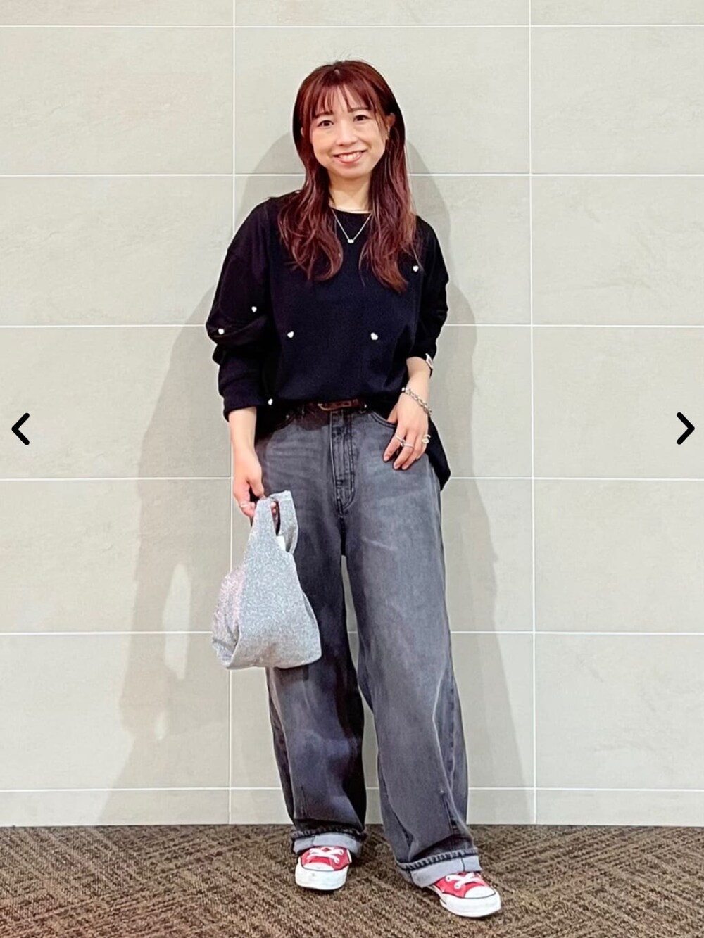 ブラック系のTシャツ/カットソー、グレー系のデニムパンツ、シルバー系のハンドバッグを着用したレディースの秋コーディネートの2枚目の写真