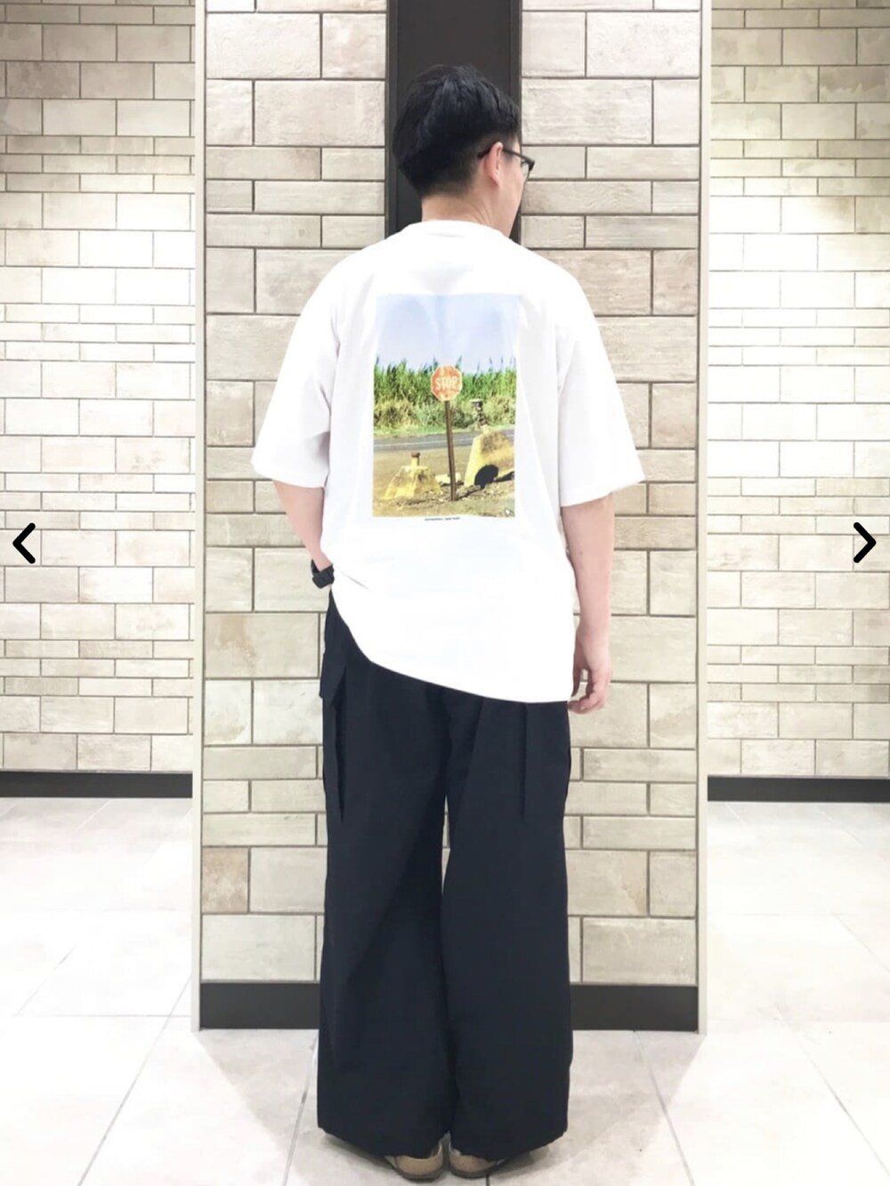 ホワイト系のTシャツ/カットソー、ブラック系のカーゴパンツを着用したメンズの夏コーディネートの3枚目の写真