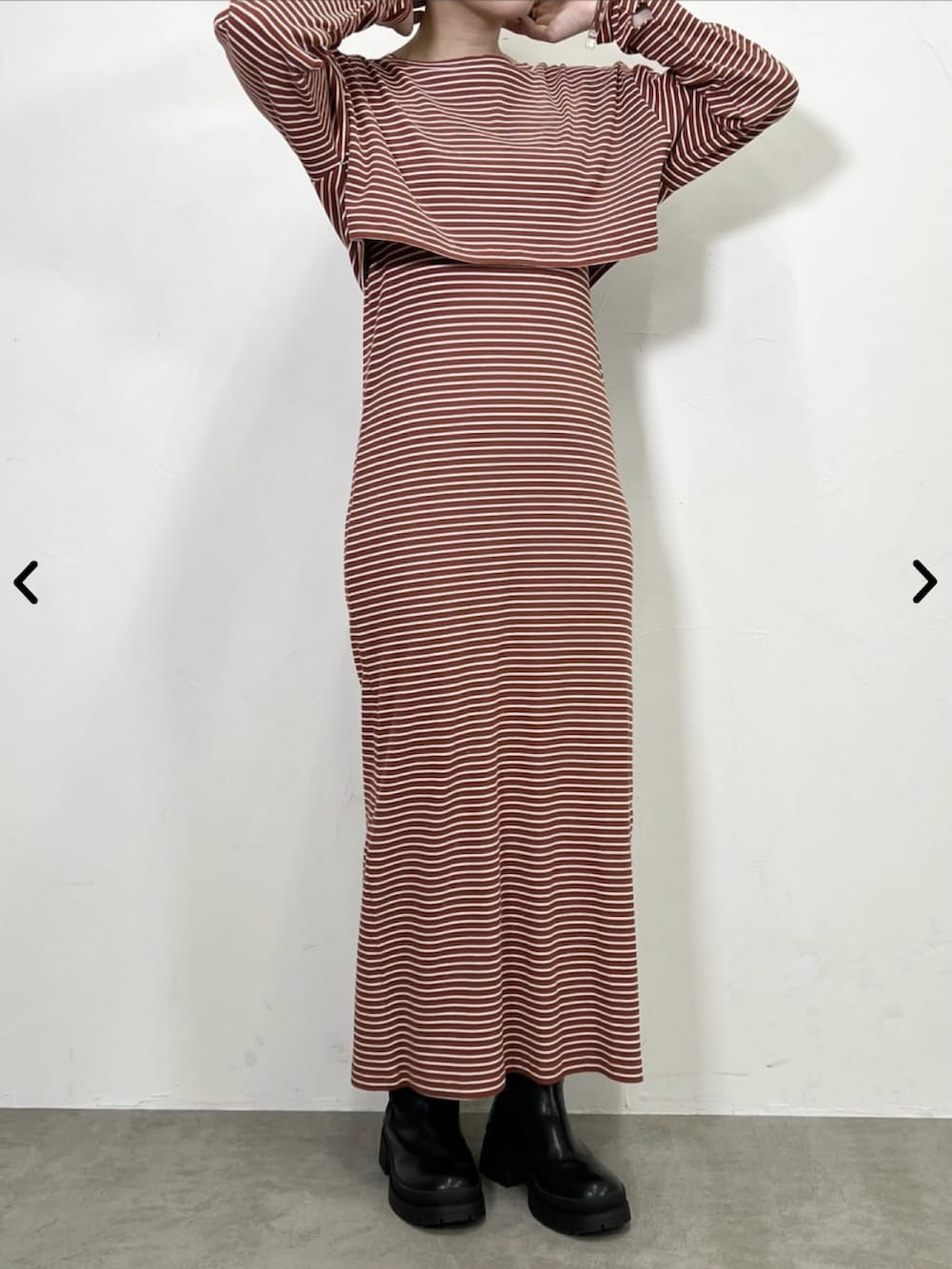 オレンジ系のワンピース、ブラック系のブーツを着用したレディースの夏コーディネートの2枚目の写真