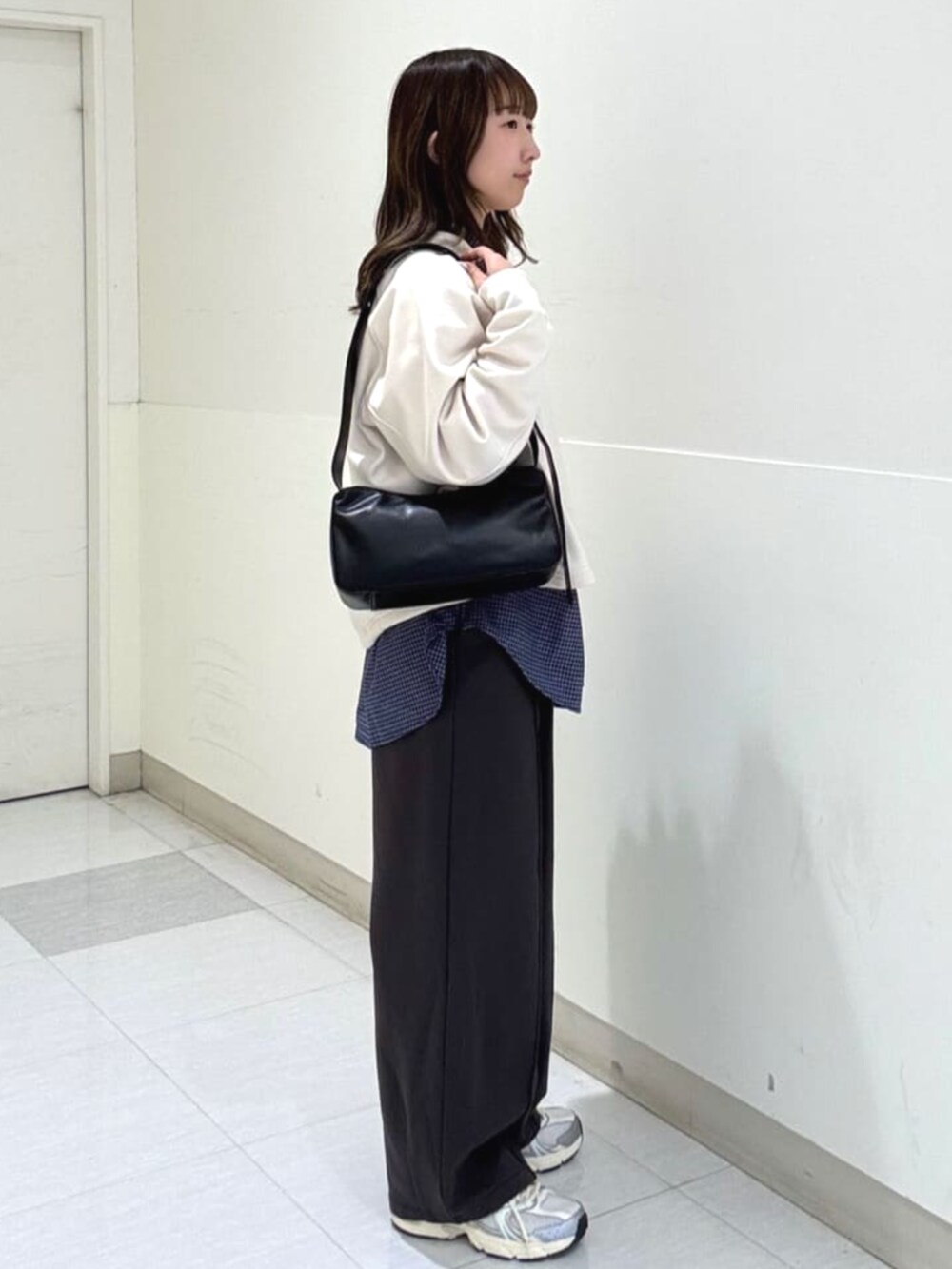 シルバー系のスニーカー、ブルー系のシャツ/ブラウス、ブラック系のスラックスを着用したレディースの冬コーディネートの2枚目の写真