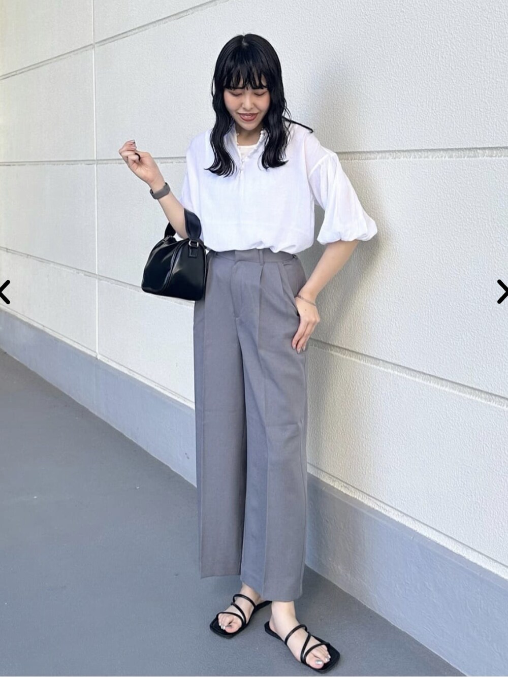 ホワイト系のシャツ/ブラウス、グレー系のスラックス、ブラック系のショルダーバッグを着用したレディースの夏コーディネートの2枚目の写真