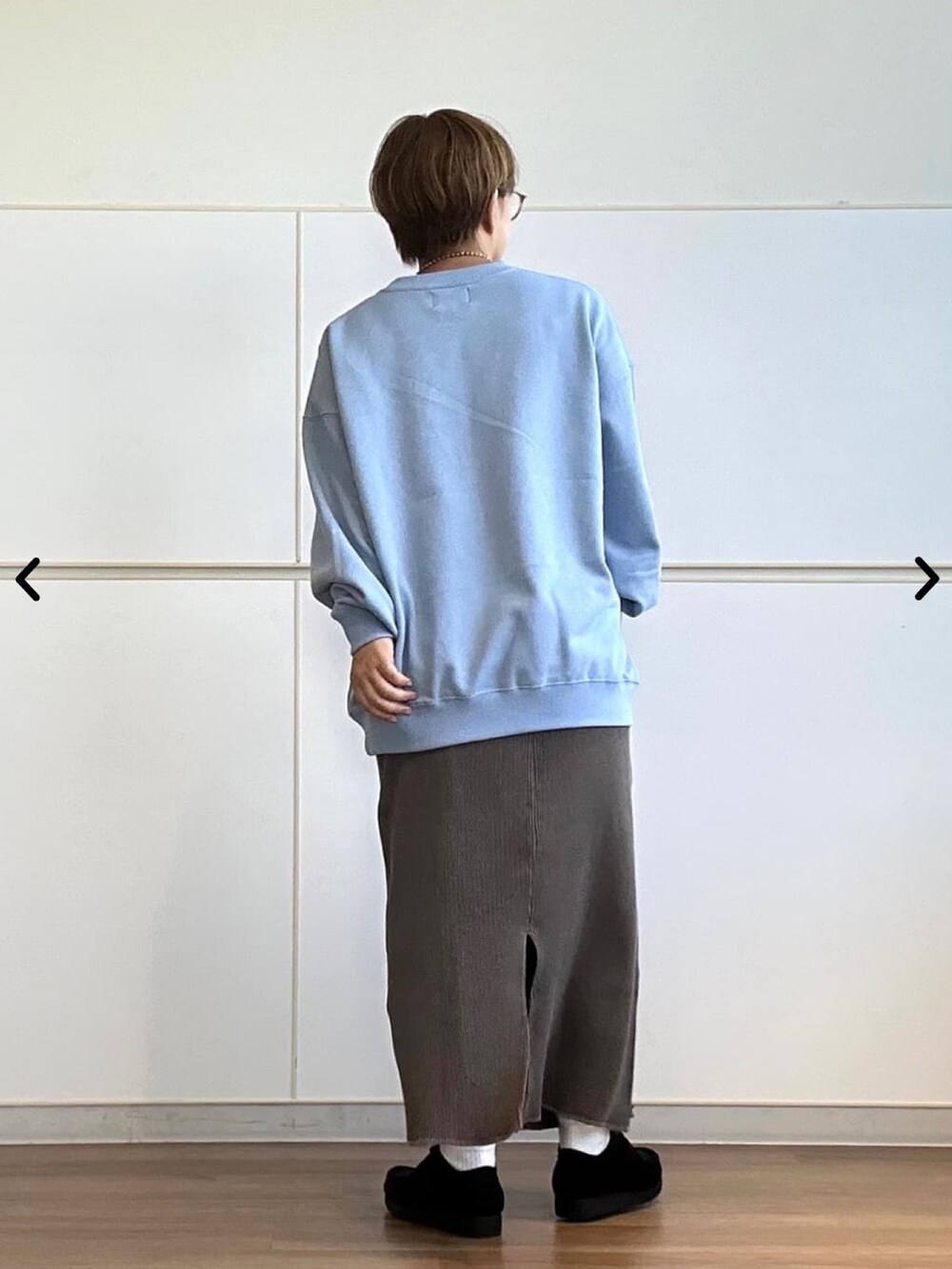 ブルー系のスウェット、グレー系のスカートを着用したレディースの秋コーディネートの2枚目の写真