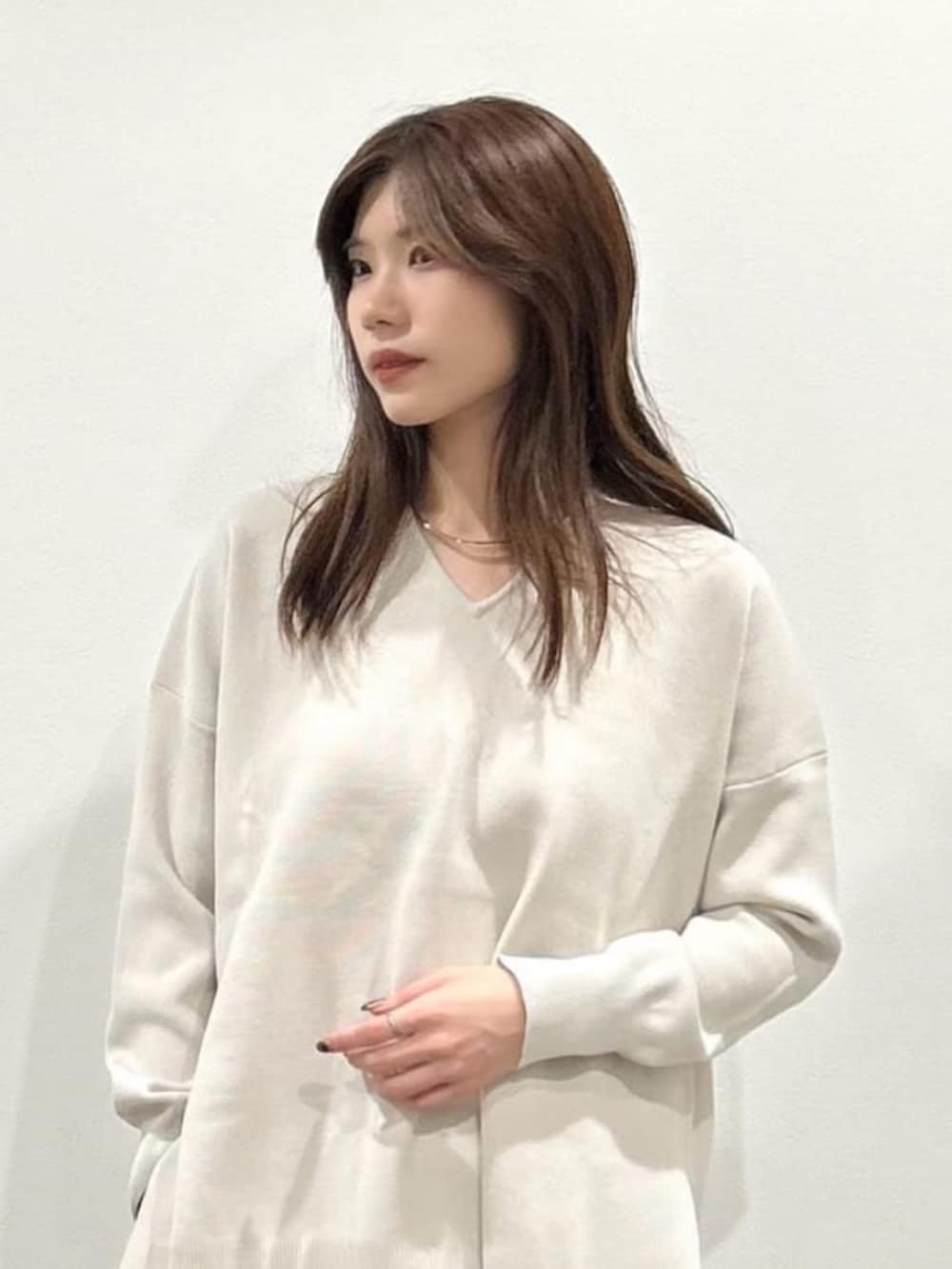 ホワイト系のニット/セーター、グレー系のその他パンツ、ブラック系のローファーを着用したレディースの秋コーディネートの2枚目の写真