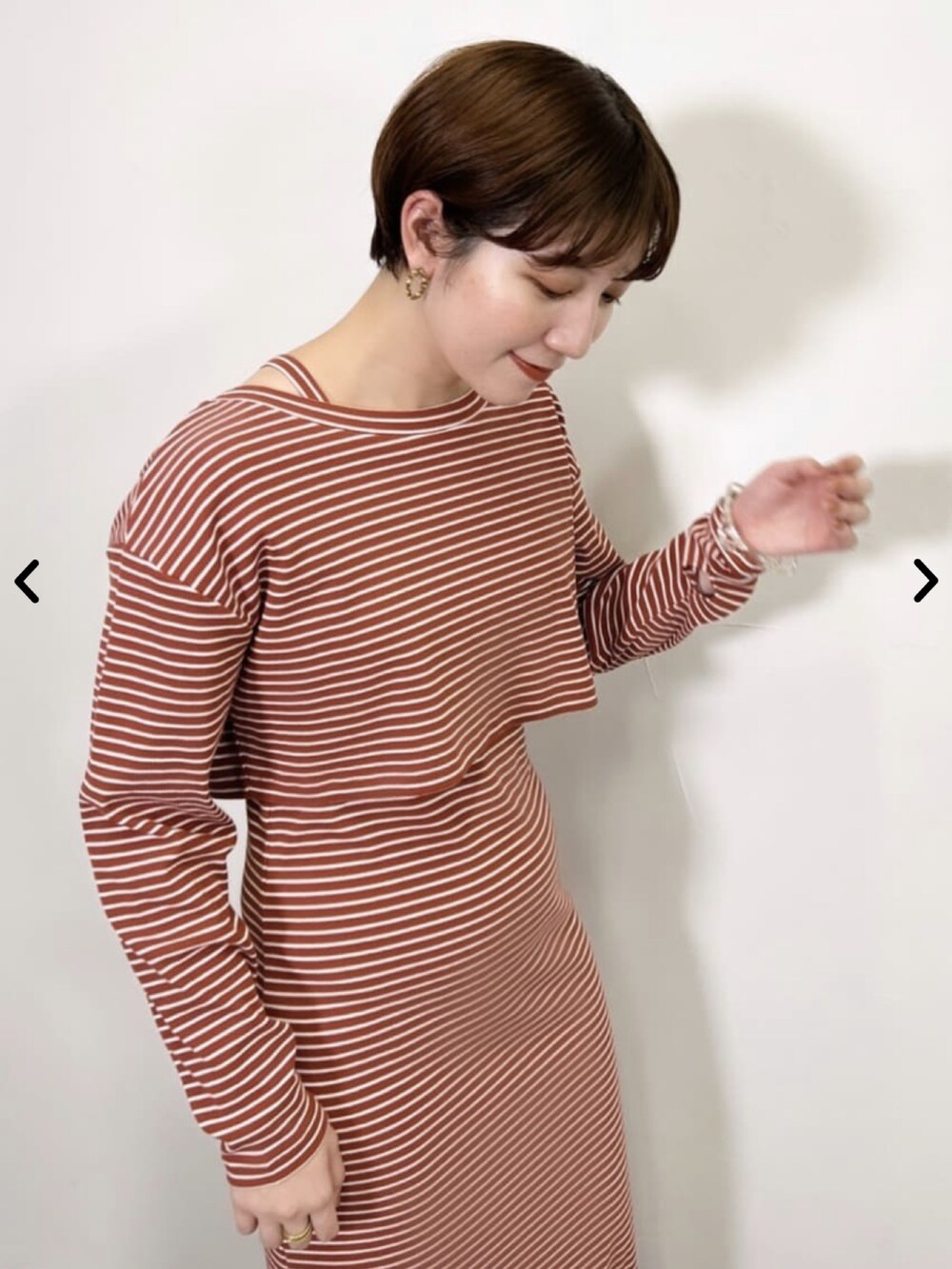 オレンジ系のワンピース、ブラック系のブーツを着用したレディースの夏コーディネートの4枚目の写真