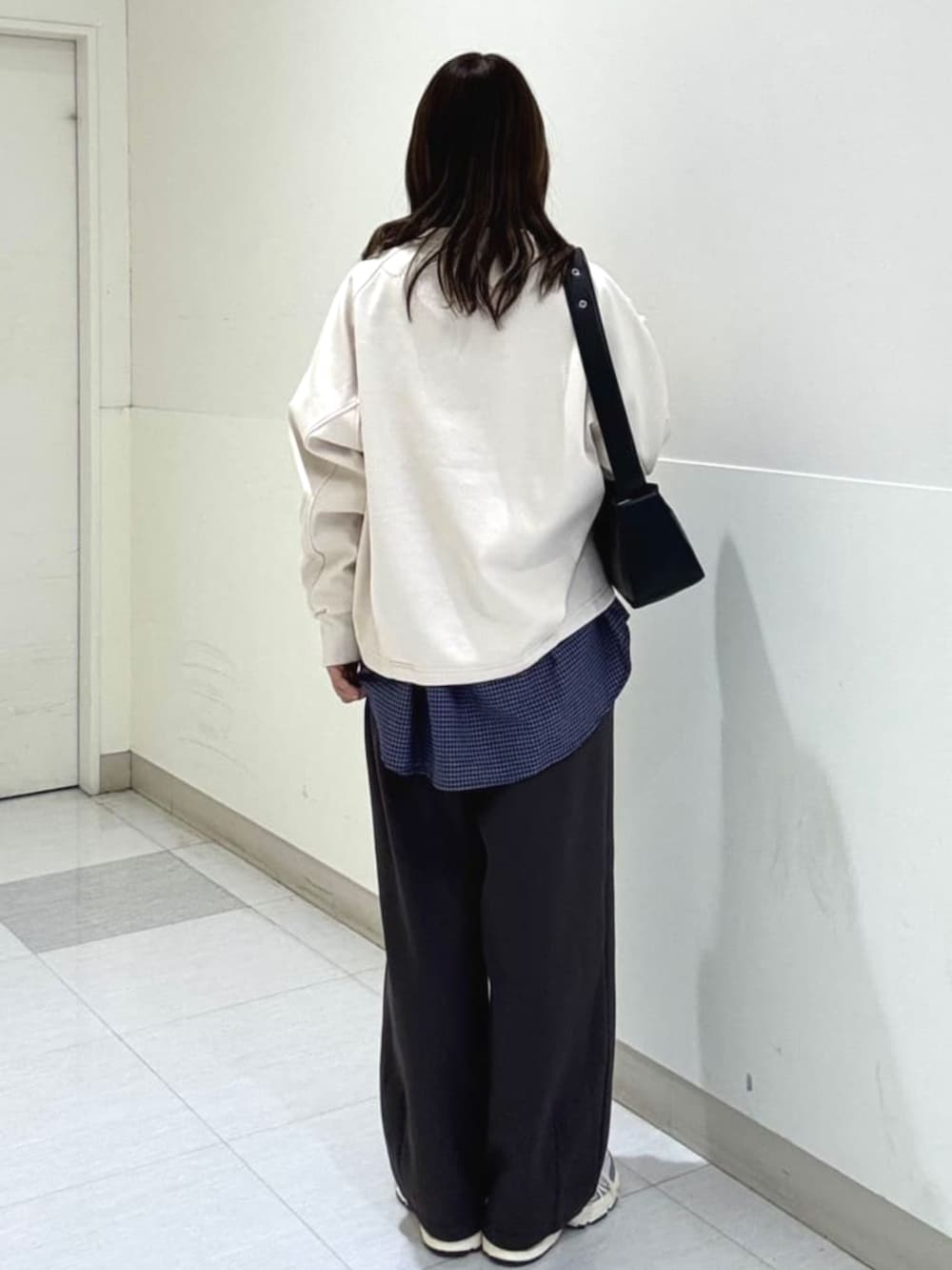 シルバー系のスニーカー、ブルー系のシャツ/ブラウス、ブラック系のスラックスを着用したレディースの冬コーディネートの3枚目の写真