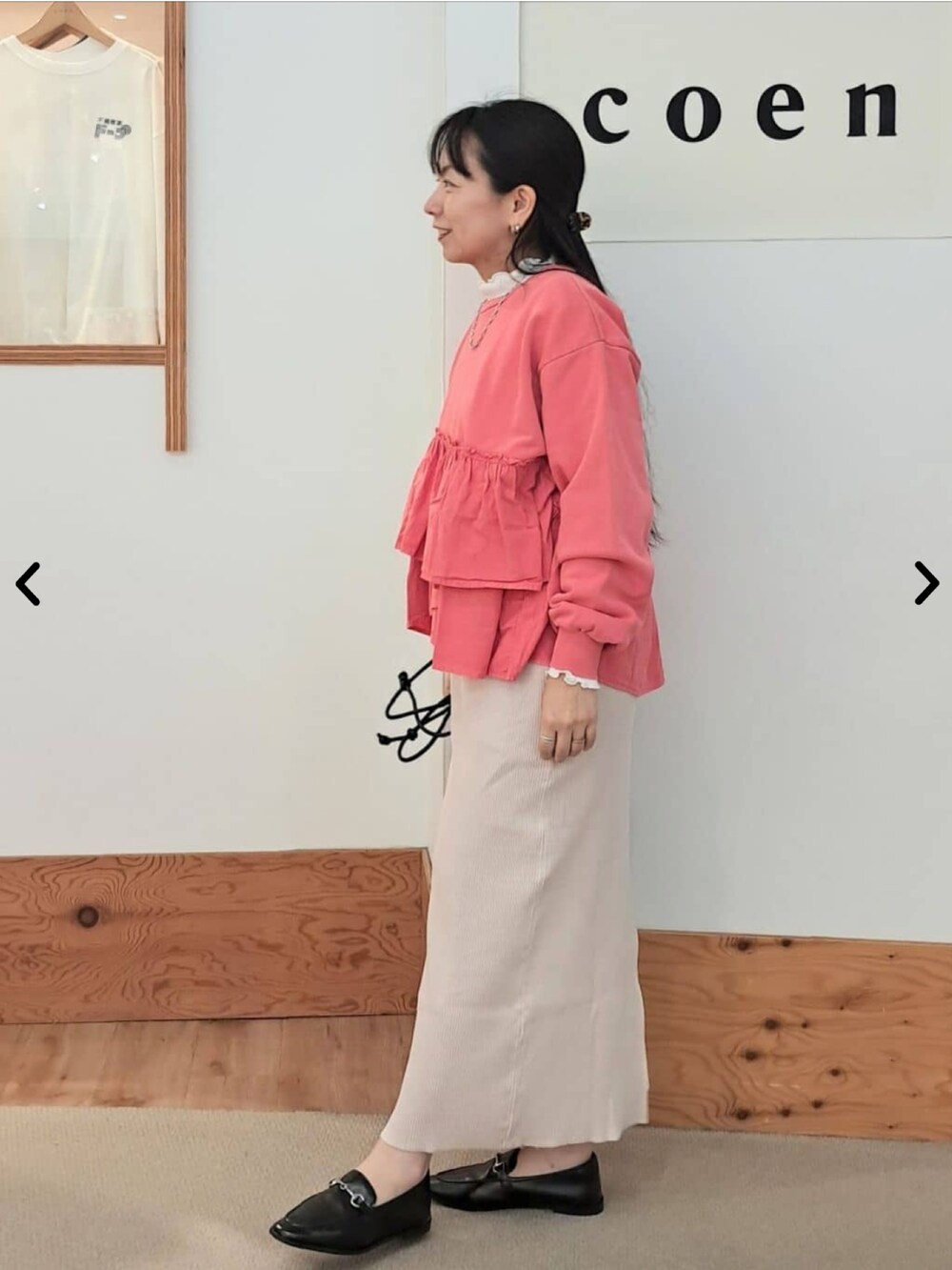 レッド系のTシャツ/カットソー、ベージュ系のスカート、ホワイト系のTシャツ/カットソーを着用したレディースの秋コーディネートの2枚目の写真