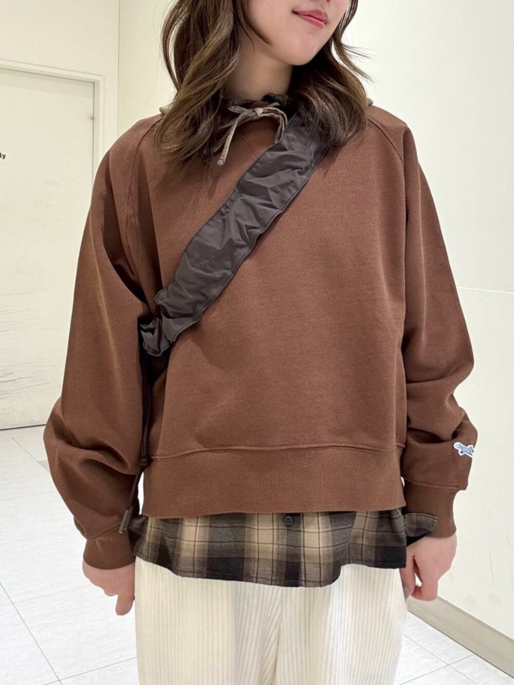 ホワイト系のその他パンツ、ブラウン系のショルダーバッグ、ホワイト系のスニーカーを着用したレディースの冬コーディネートの2枚目の写真