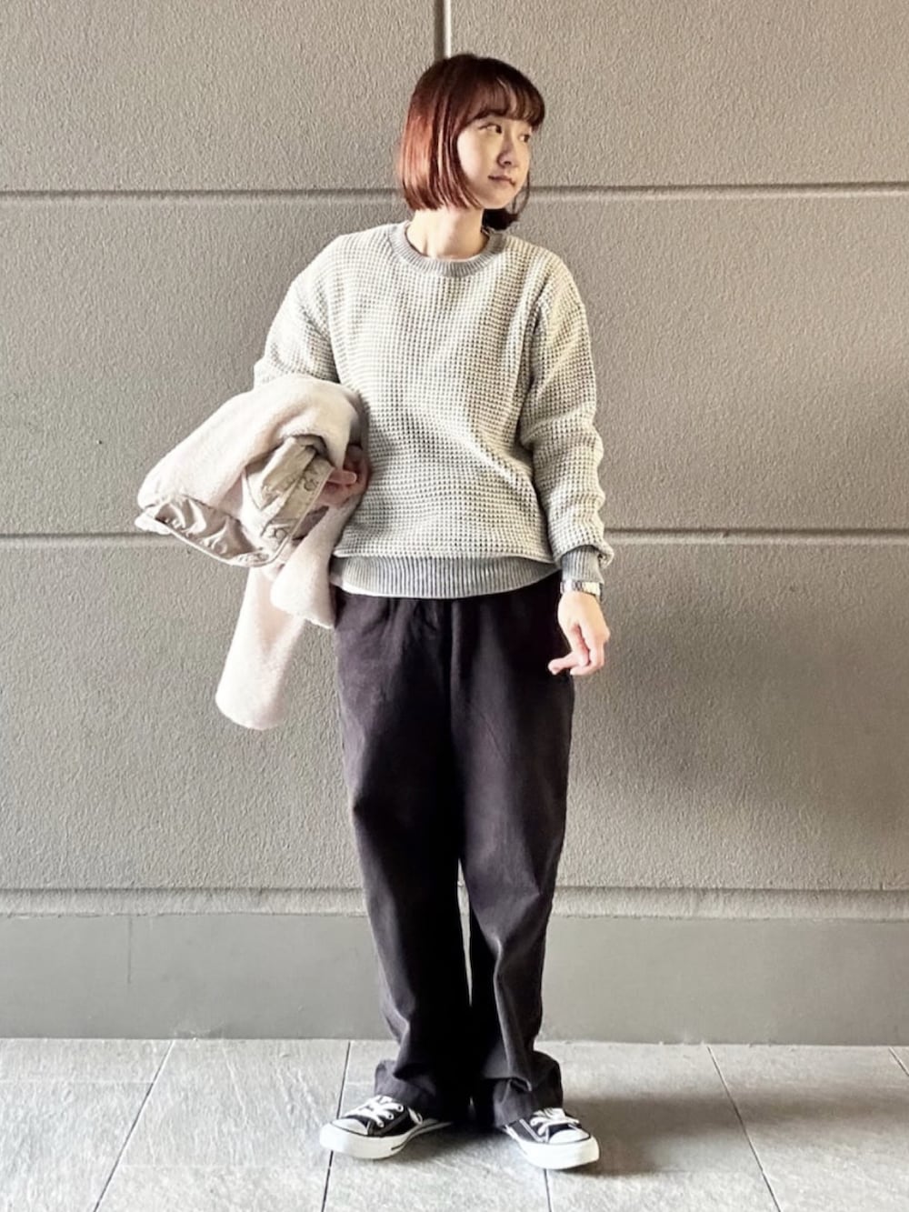 グレー系のニット/セーター、ホワイト系のブルゾン、グレー系のその他パンツを着用したレディースの秋コーディネートの2枚目の写真