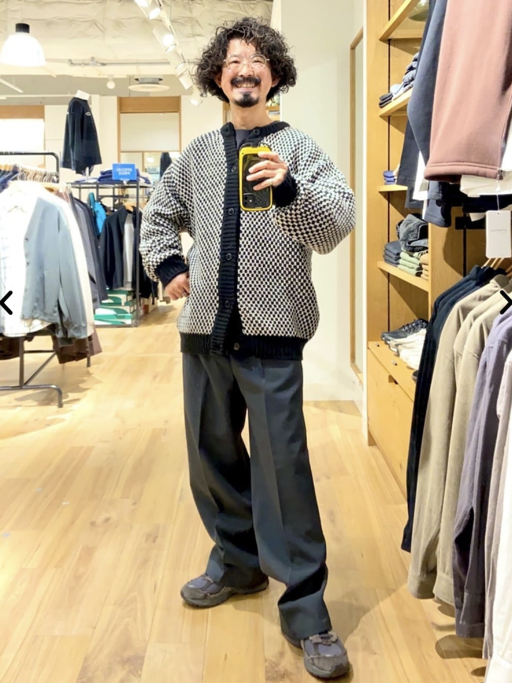 ブラック系のベスト、ブラック系のカーディガン/ボレロ、グレー系のスラックスを着用したメンズの秋コーディネートの2枚目の写真
