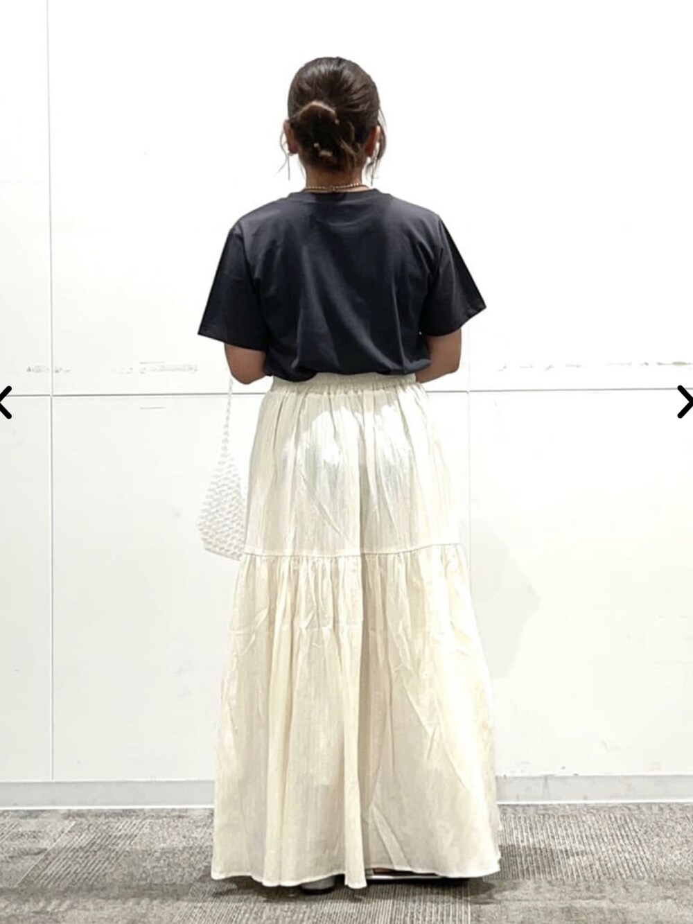 グレー系のTシャツ/カットソー、ホワイト系のスカート、シルバー系のネックレスを着用したレディースの夏コーディネートの3枚目の写真