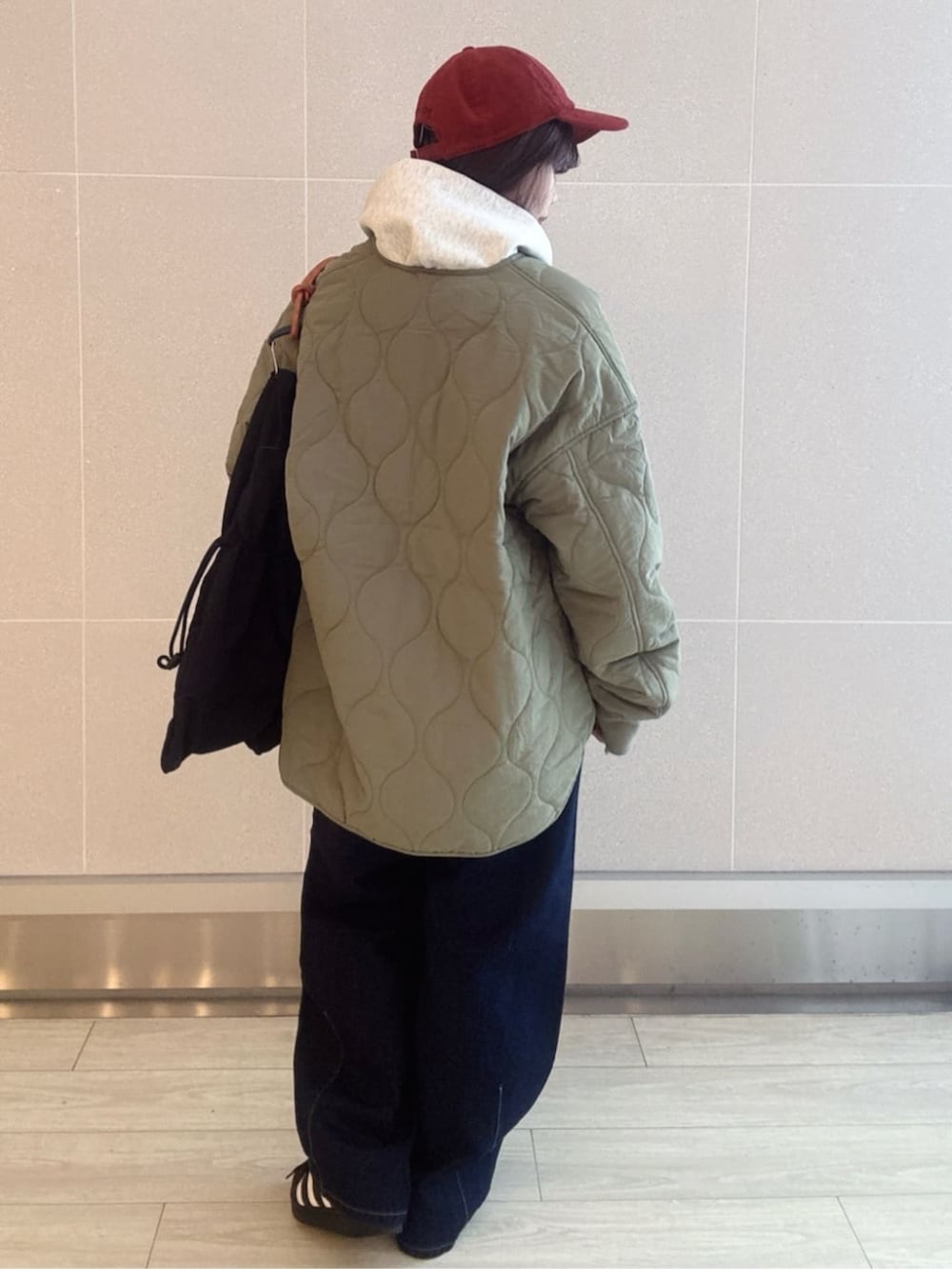 ブルー系のデニムパンツ、グリーン系のブルゾン、グレー系のパーカーを着用したレディースの秋コーディネートの2枚目の写真