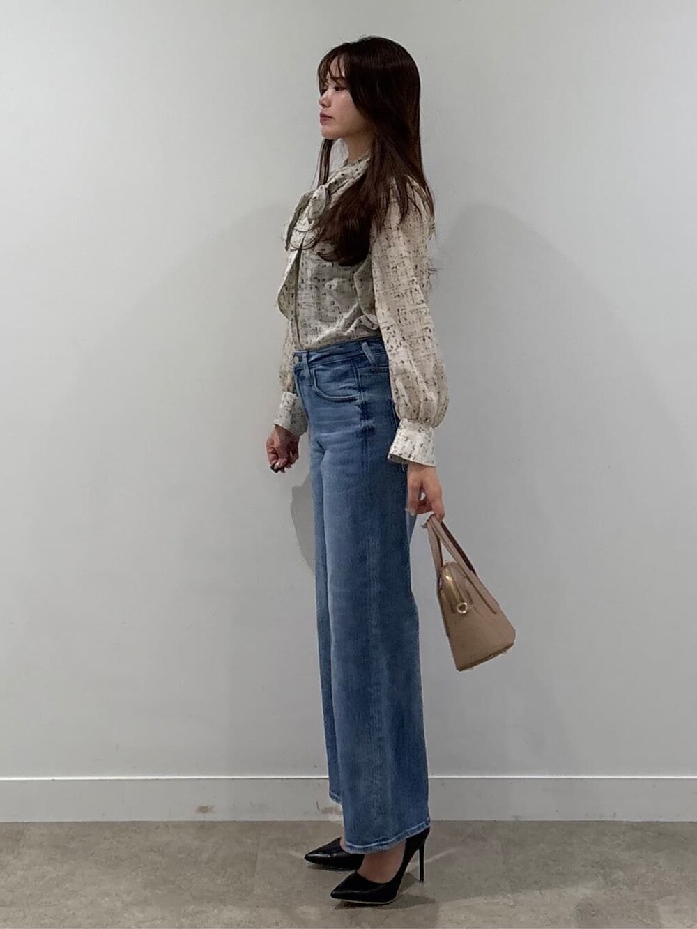 ベージュ系のシャツ/ブラウス、ブルー系のデニムパンツを着用したレディースの春コーディネートの2枚目の写真
