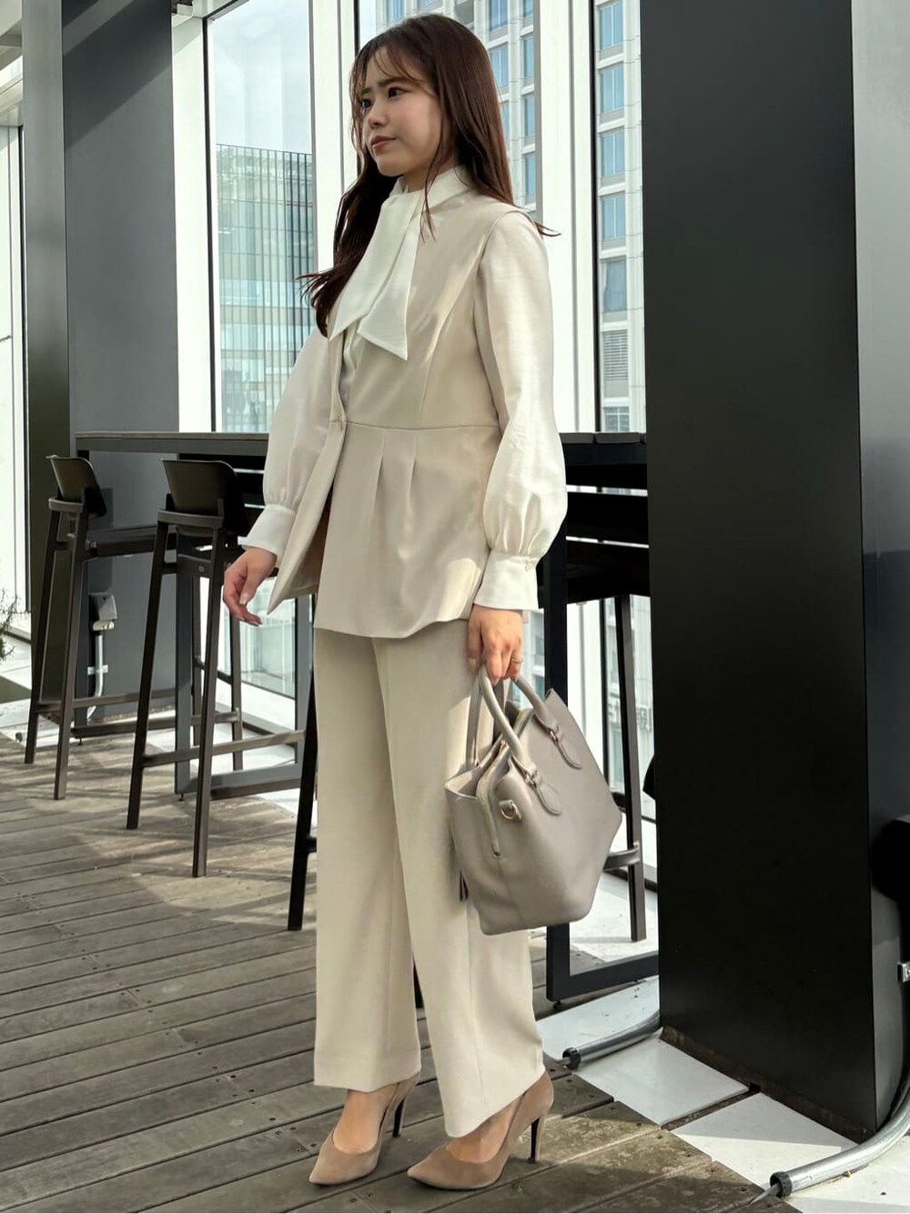 ベージュ系のベスト、ベージュ系のその他パンツ、ホワイト系のシャツ/ブラウスを着用したレディースの冬コーディネートの2枚目の写真