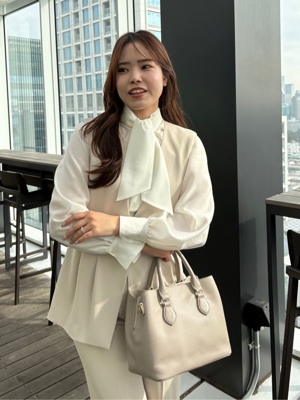 ベージュ系のベスト、ベージュ系のその他パンツ、ホワイト系のシャツ/ブラウスを着用したレディースの冬コーディネートの6枚目の写真