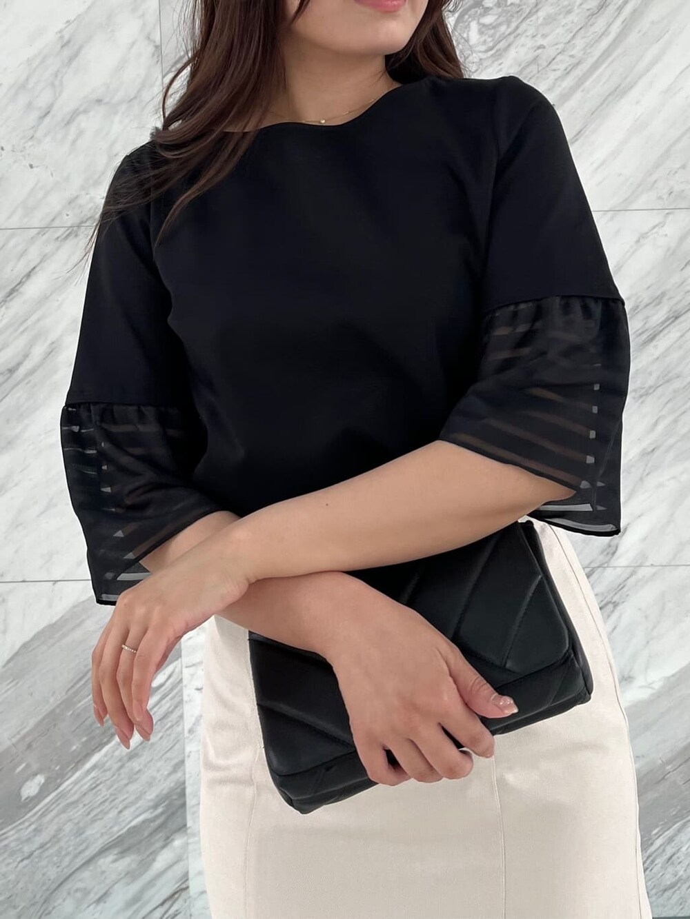 ブラック系のTシャツ/カットソー、ベージュ系のスカートを着用したレディースの春コーディネートの6枚目の写真