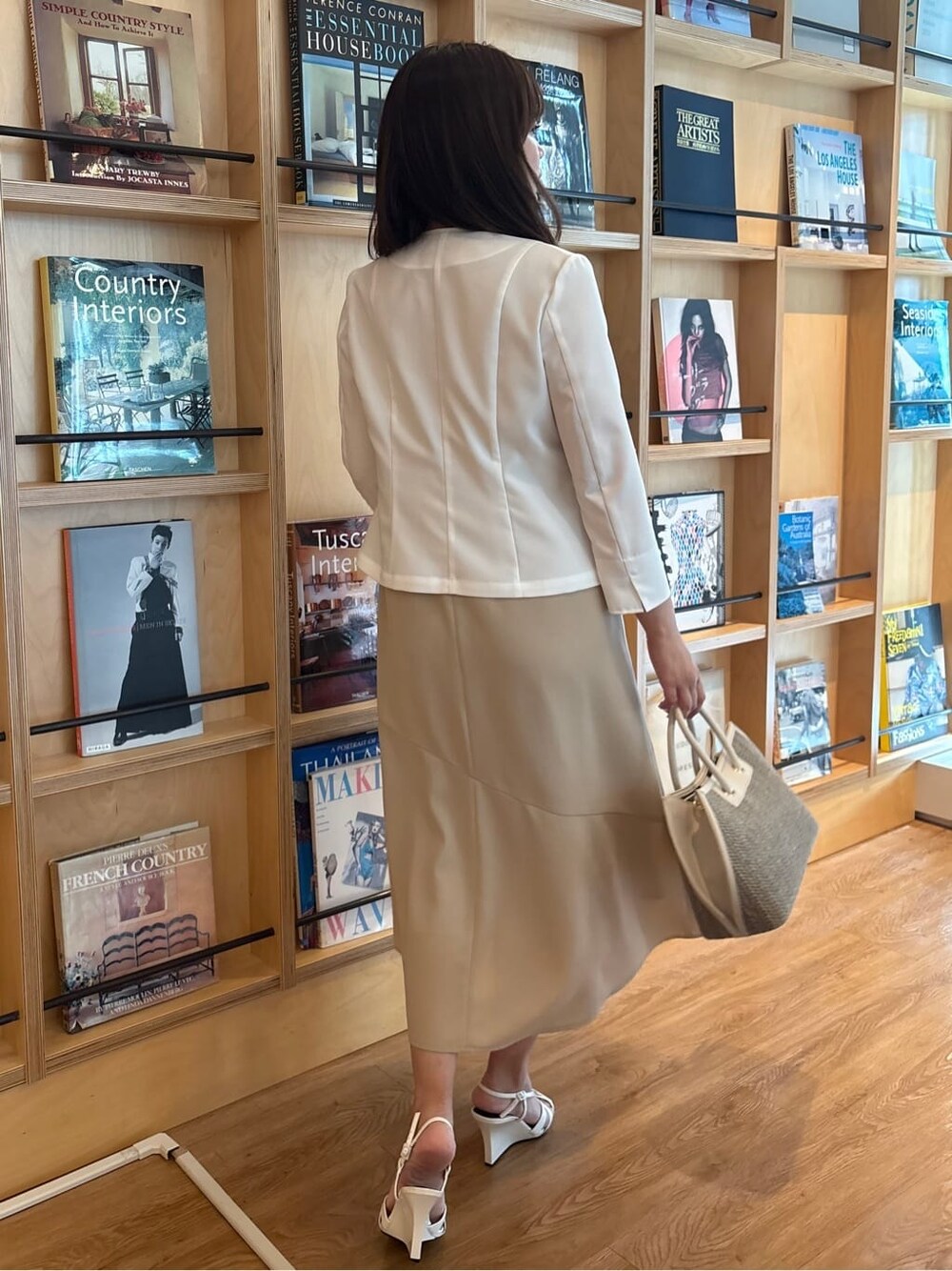 ホワイト系のノーカラージャケット、ベージュ系のワンピースを着用したレディースの夏コーディネートの3枚目の写真