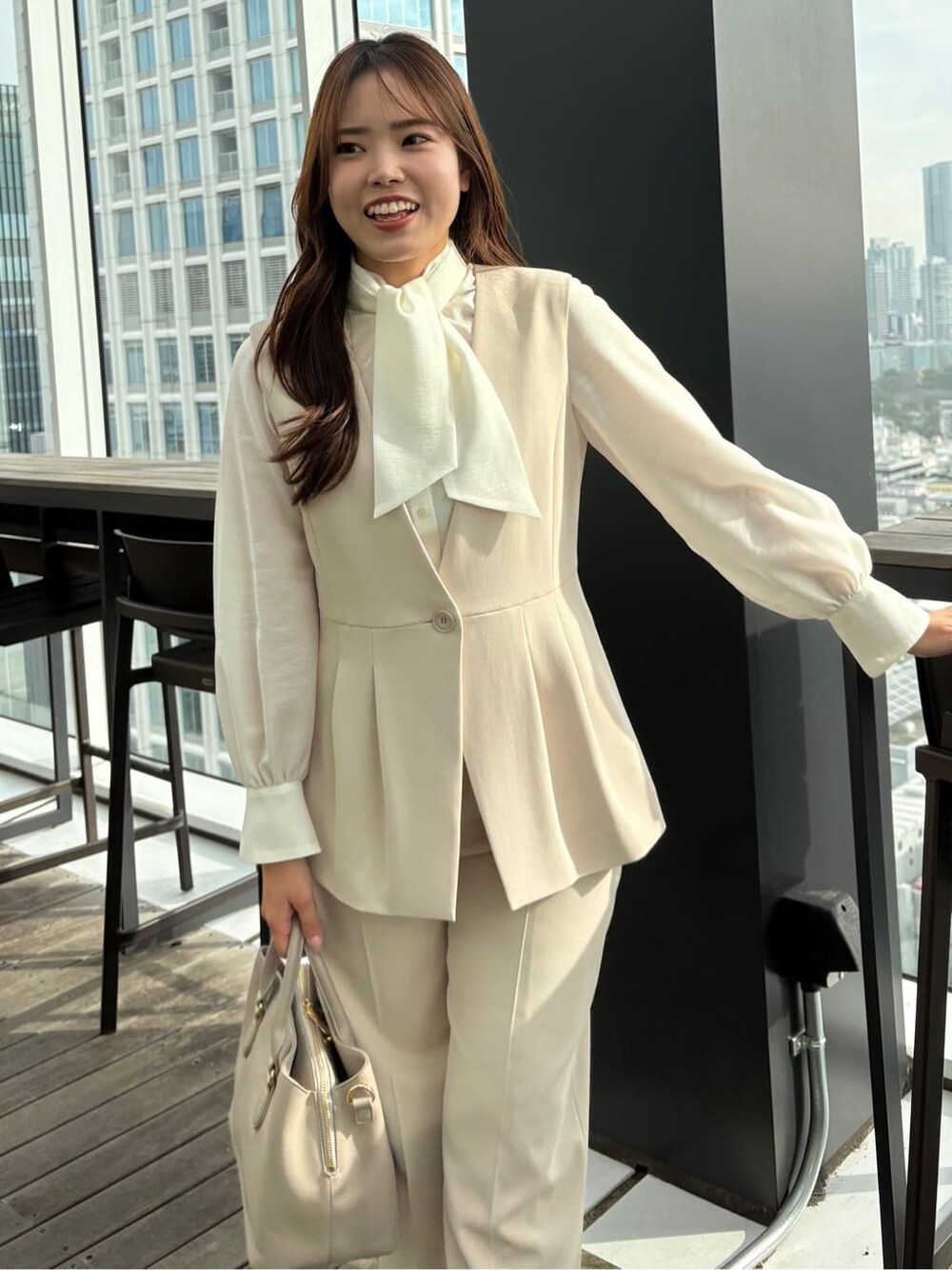 ベージュ系のベスト、ベージュ系のその他パンツ、ホワイト系のシャツ/ブラウスを着用したレディースの冬コーディネートの7枚目の写真