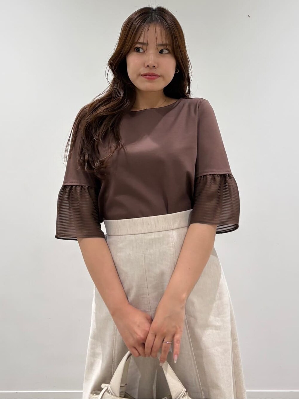 ブラウン系のTシャツ/カットソー、ベージュ系のスカートを着用したレディースの春コーディネートの8枚目の写真