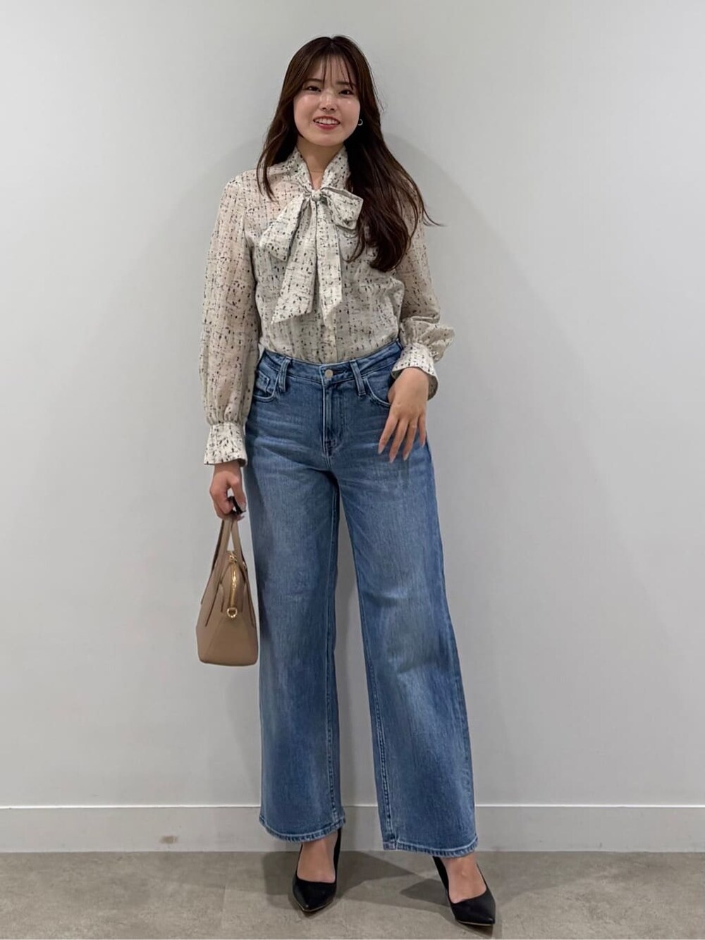 ベージュ系のシャツ/ブラウス、ブルー系のデニムパンツを着用したレディースの春コーディネートの4枚目の写真