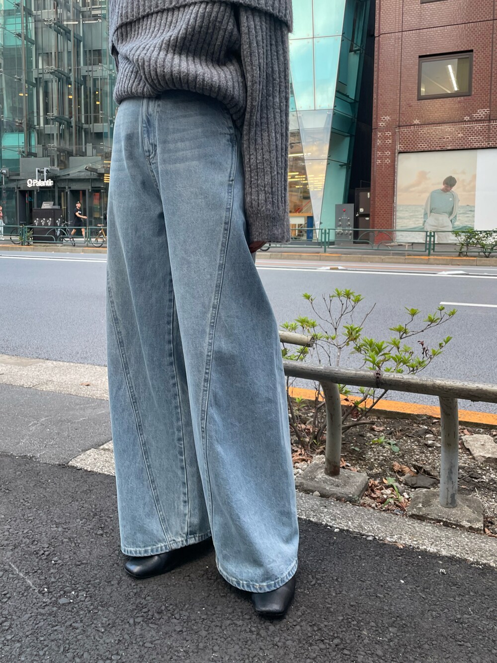 グレー系のニット/セーター、ブルー系のデニムパンツを着用したレディースの秋コーディネートの5枚目の写真