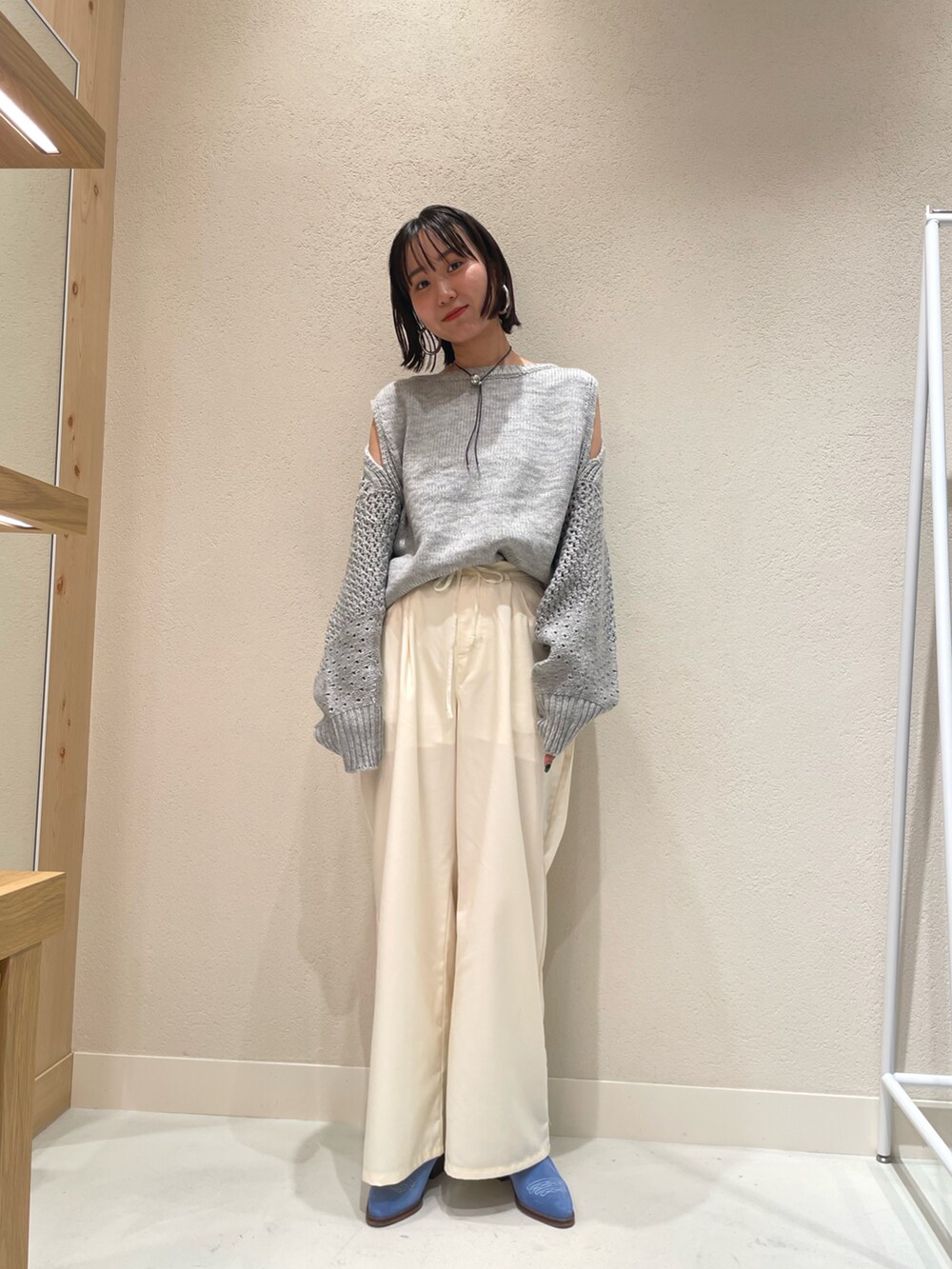 グレー系のニット/セーター、グレー系のスラックス、ブラック系のその他パンツを着用したレディースの秋コーディネートの3枚目の写真