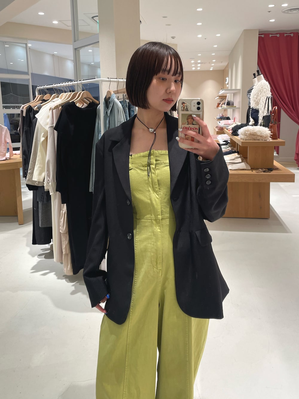 グリーン系のオールインワン・サロペット、ブラック系のテーラードジャケットを着用したレディースの春コーディネートの2枚目の写真