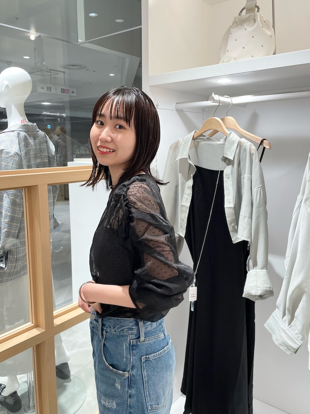 ブラック系のシャツ/ブラウス、ブルー系のデニムパンツを着用したレディースの秋コーディネートの2枚目の写真