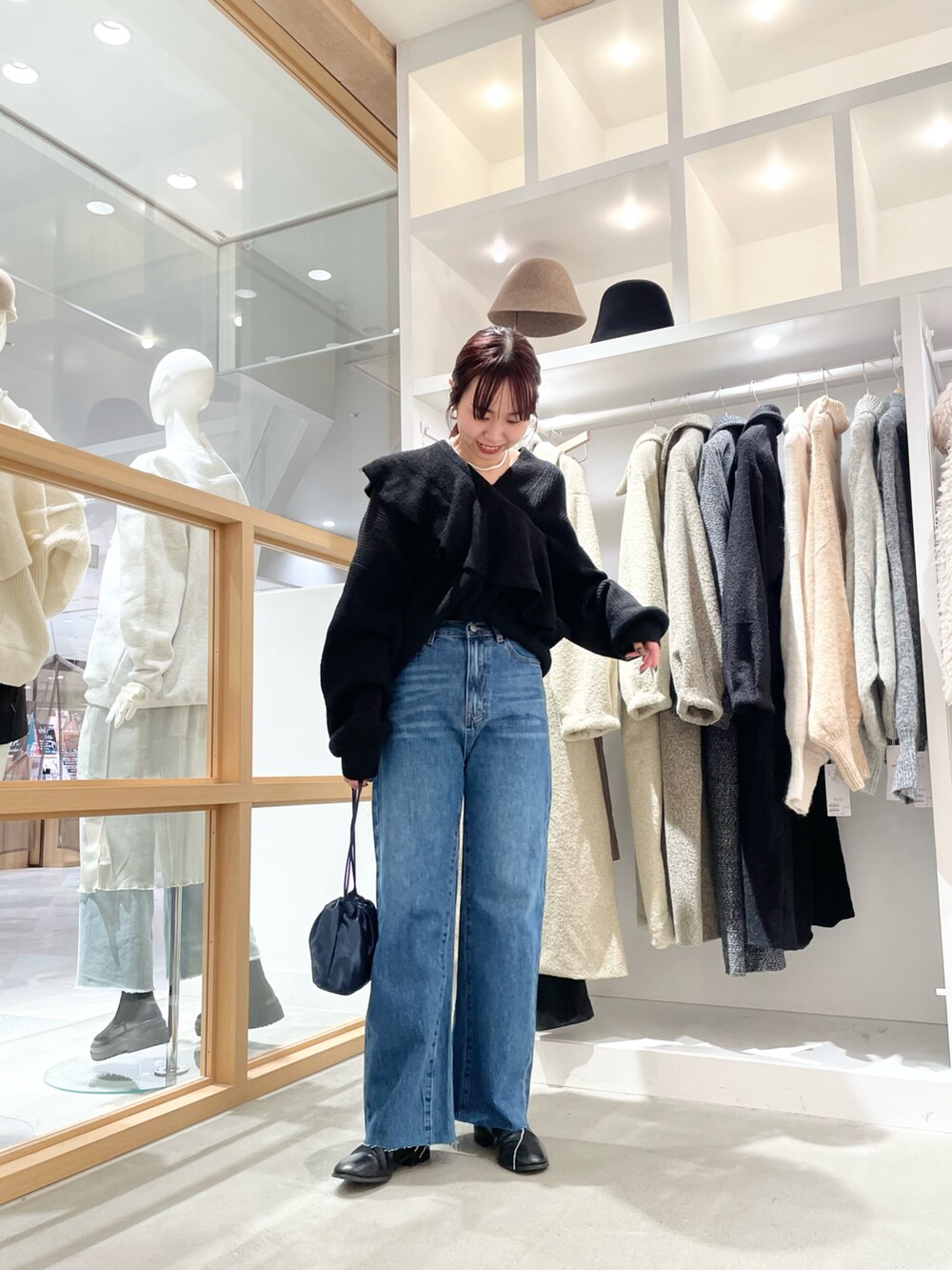 ブルー系のデニムパンツ、ブラック系のニット/セーターを着用したレディースの秋コーディネートの2枚目の写真