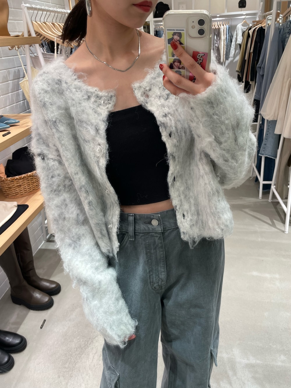 グレー系のカーディガン/ボレロ、ブラック系のキャミソール、グレー系のデニムパンツを着用したレディースの秋コーディネートの2枚目の写真