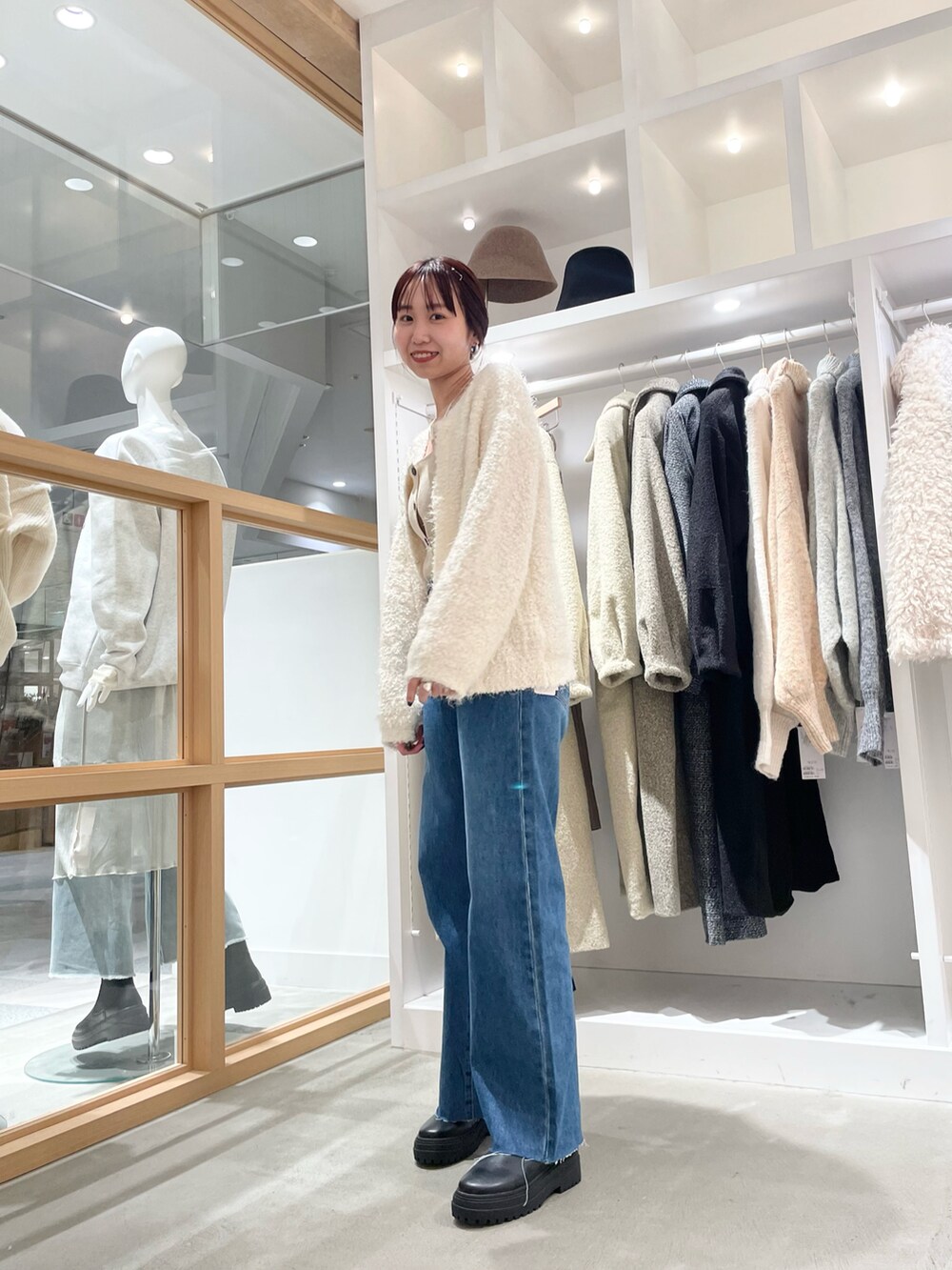 ブルー系のデニムパンツ、ホワイト系のカーディガン/ボレロを着用したレディースの秋コーディネートの3枚目の写真