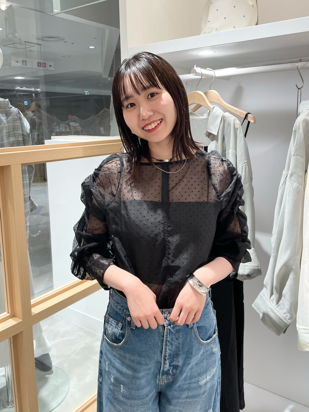 ブラック系のシャツ/ブラウス、ブルー系のデニムパンツを着用したレディースの秋コーディネートの3枚目の写真