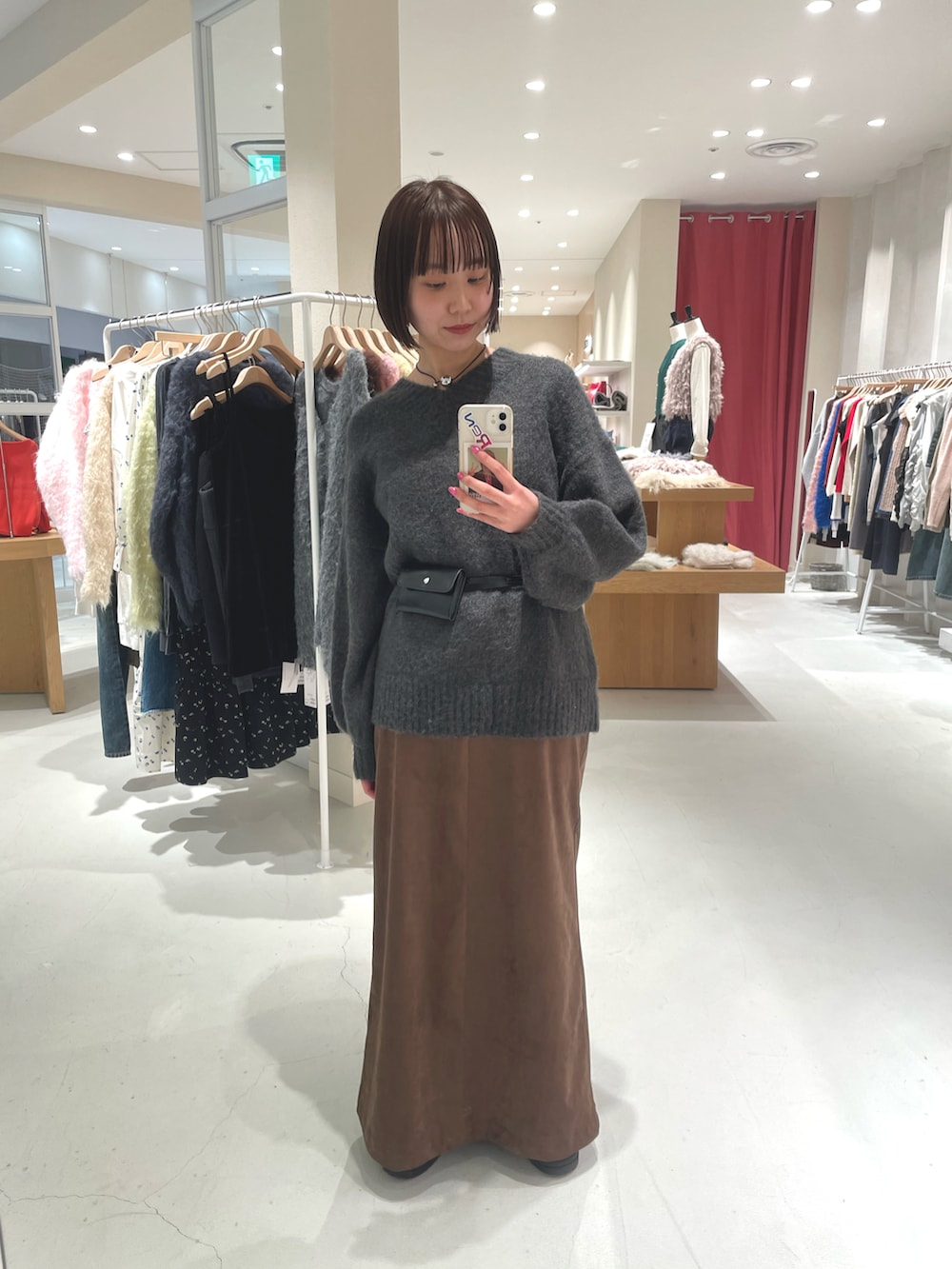 グレー系のニット/セーター、ブラウン系のスカートを着用したレディースの冬コーディネートの3枚目の写真
