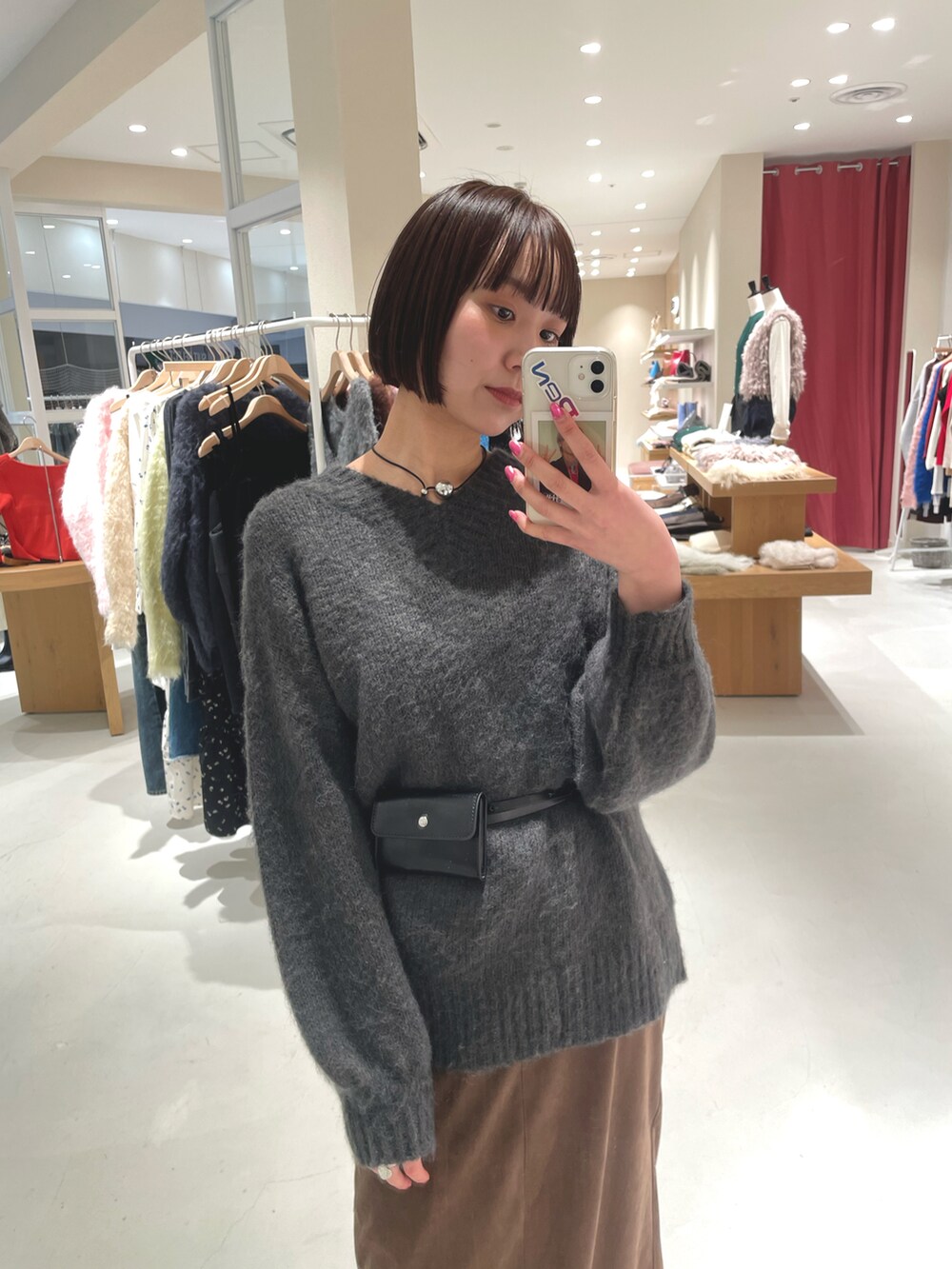 グレー系のニット/セーター、ブラウン系のスカートを着用したレディースの冬コーディネートの2枚目の写真