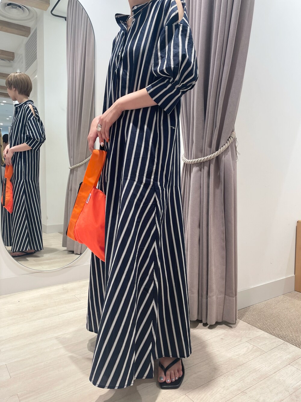 ブルー系のワンピース、ブルー系のハンドバッグ、ブラック系のサンダルを着用したレディースの夏コーディネートの3枚目の写真